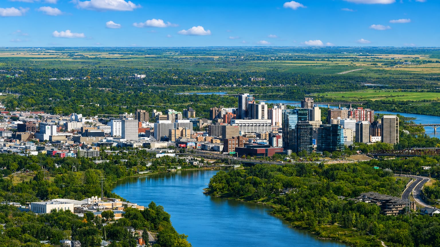 Aerial view of downtown Saskatoon along the South Saskatchewan River with prairie beyond, Canada