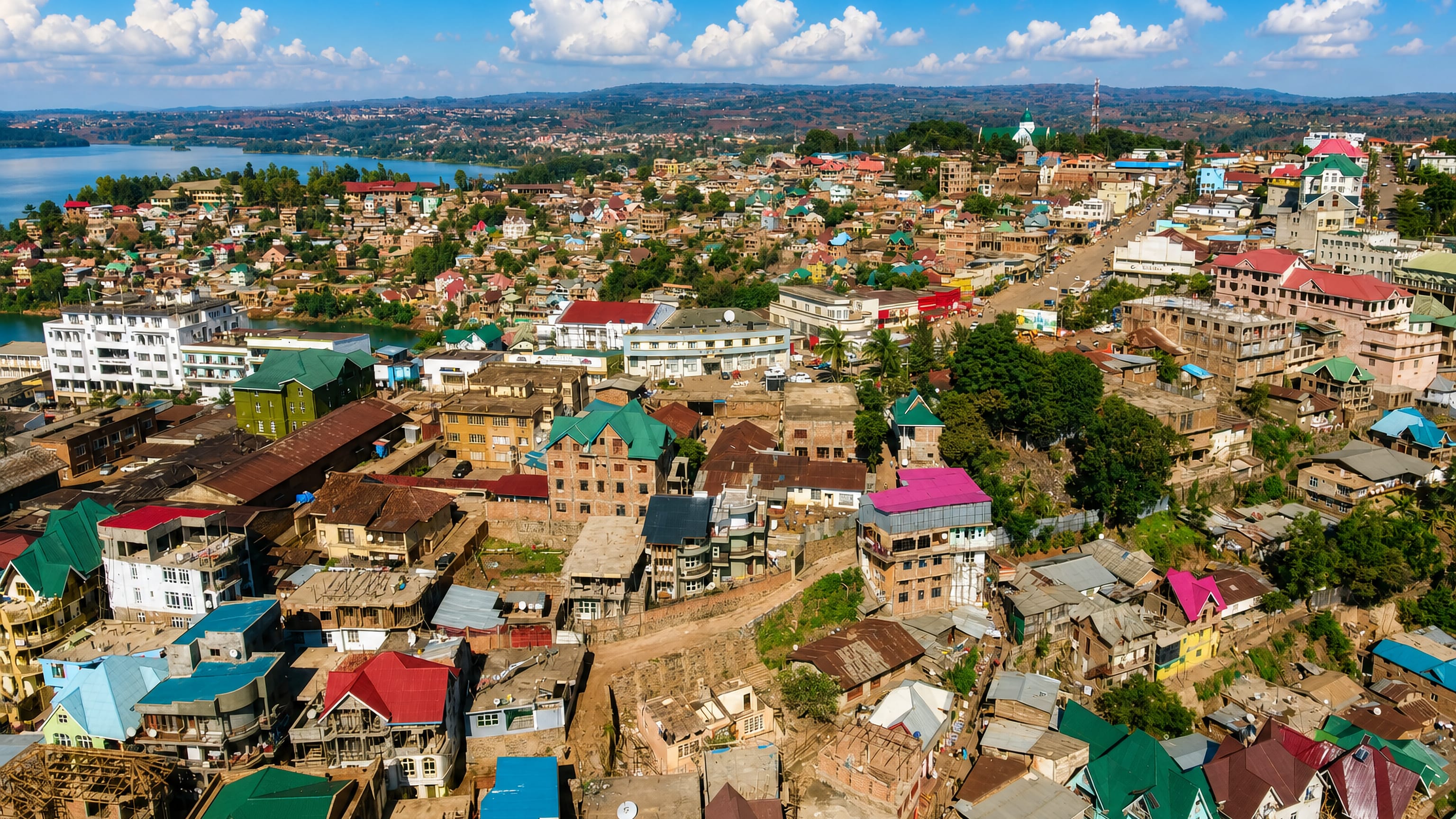 Aerial view of Bukavu, DR Congo, hillsides of coloured tin roofs above an inlet of Lake Kivu.