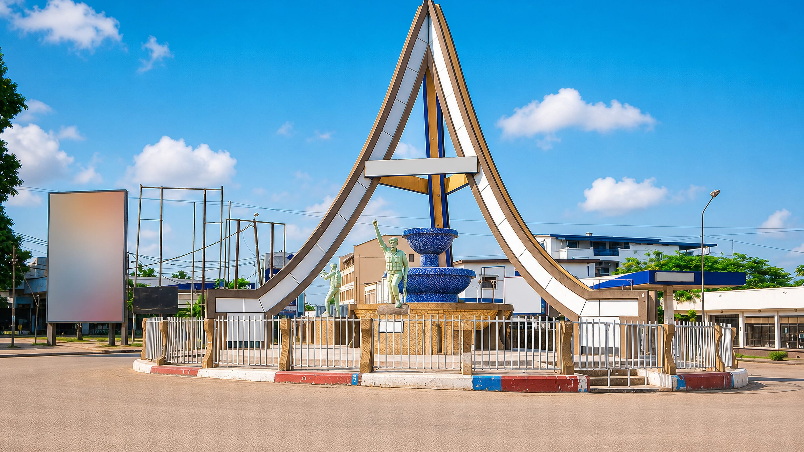Roundabout monument with a curved white arch and raised-arm statue in Kisangani, Democratic Republic of the Congo.