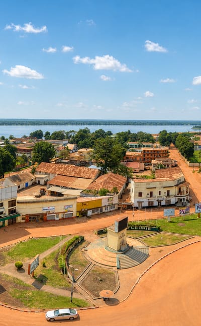 Aerial view of Bangui's central roundabout and red-earth streets beside the Ubangi River.