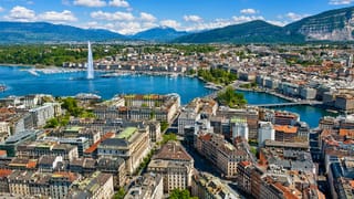 Geneva's harbour with the Jet d'Eau fountain on Lake Geneva and snow-capped Alps behind the old town