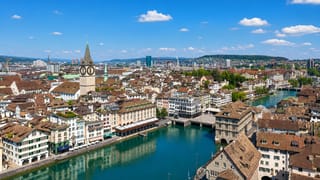 Zürich old town along the Limmat with St. Peter's clock tower and the Fraumünster spire