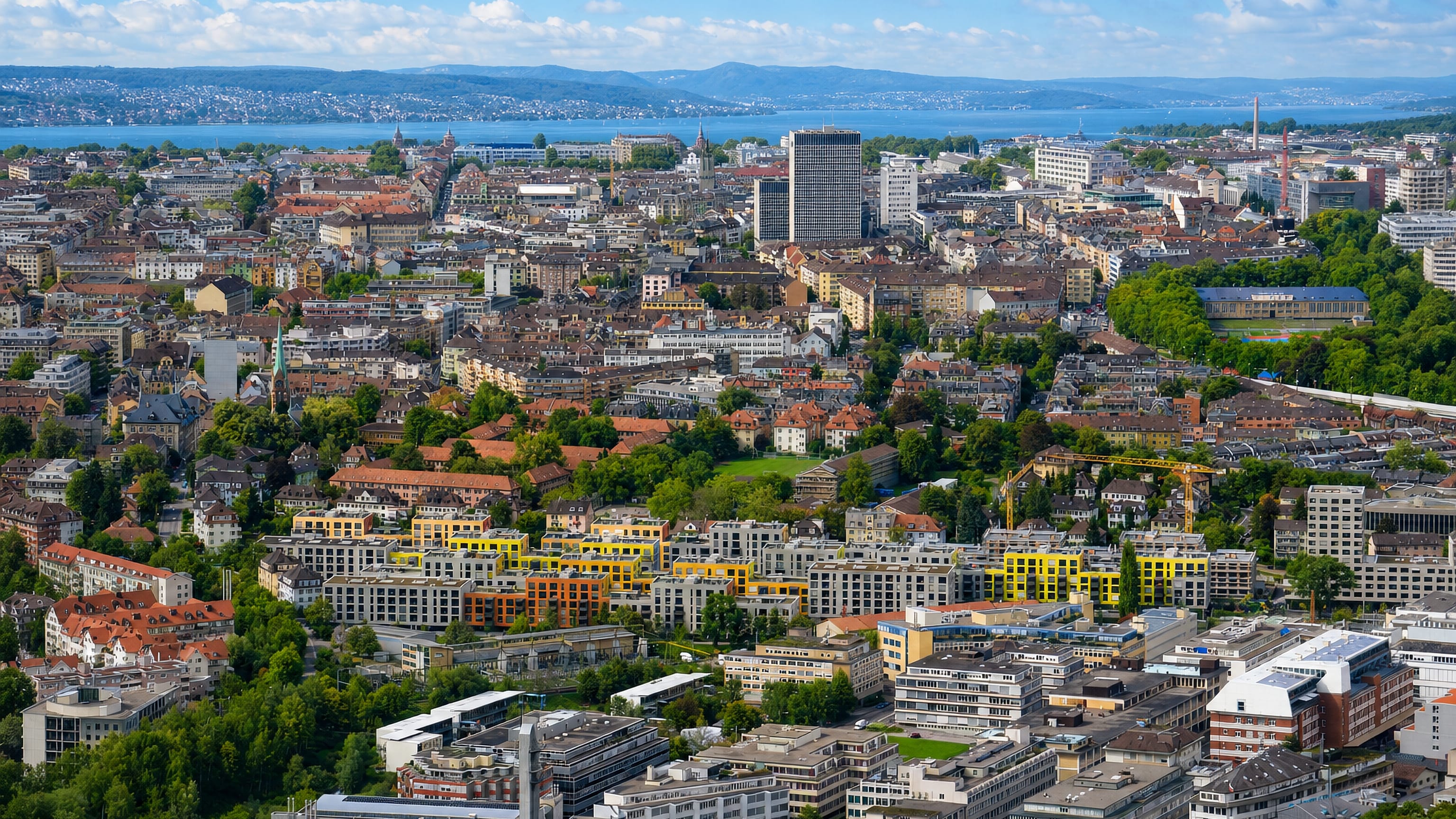 Aerial view over Friesenberg and Zürich Kreis 3 rooftops toward the city centre and Lake Zürich.