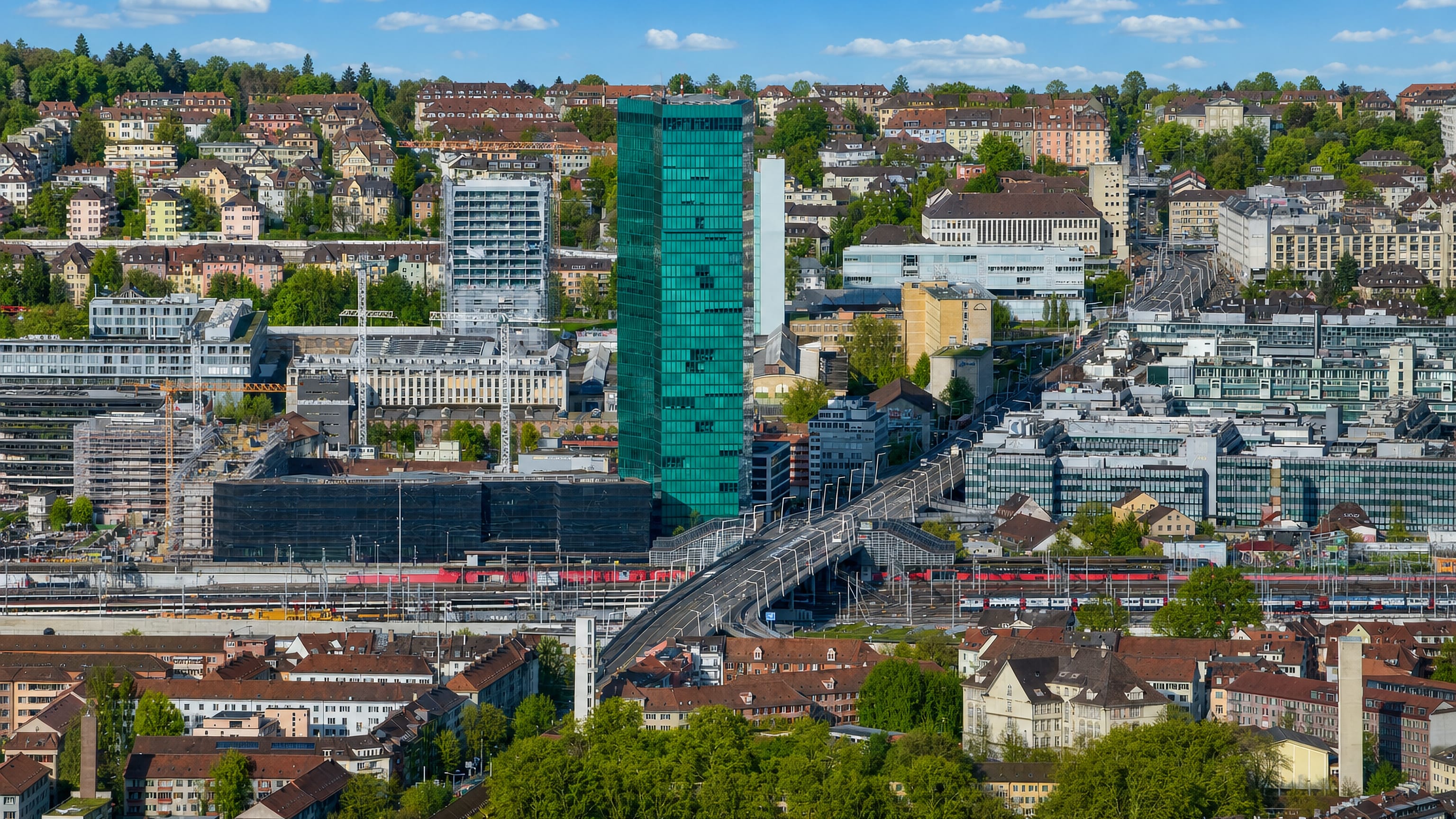 The green-glass Prime Tower above the Hardbrücke viaduct and rail yards of Zürich Kreis 5.