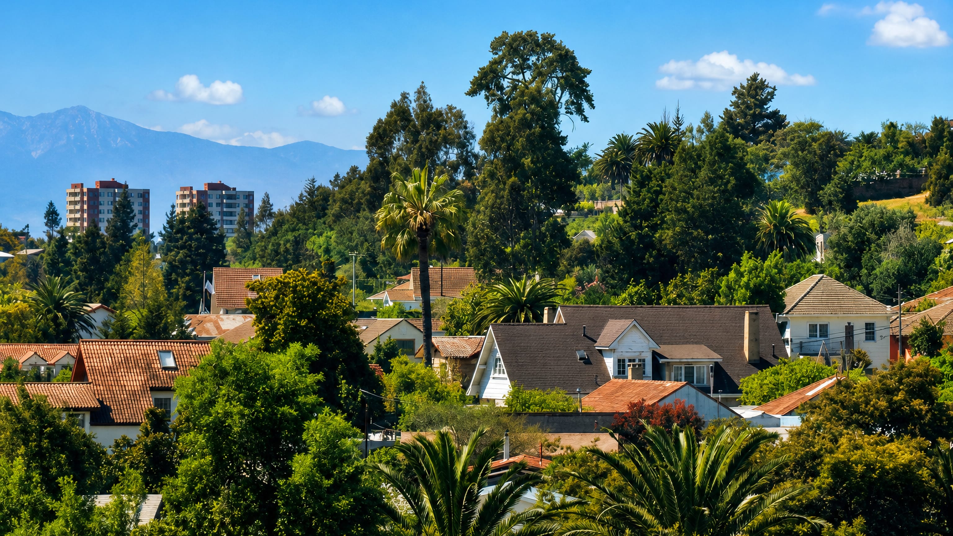 Tile-roofed houses among palms on the wooded hillsides of Quilpué, Chile, with mountains beyond