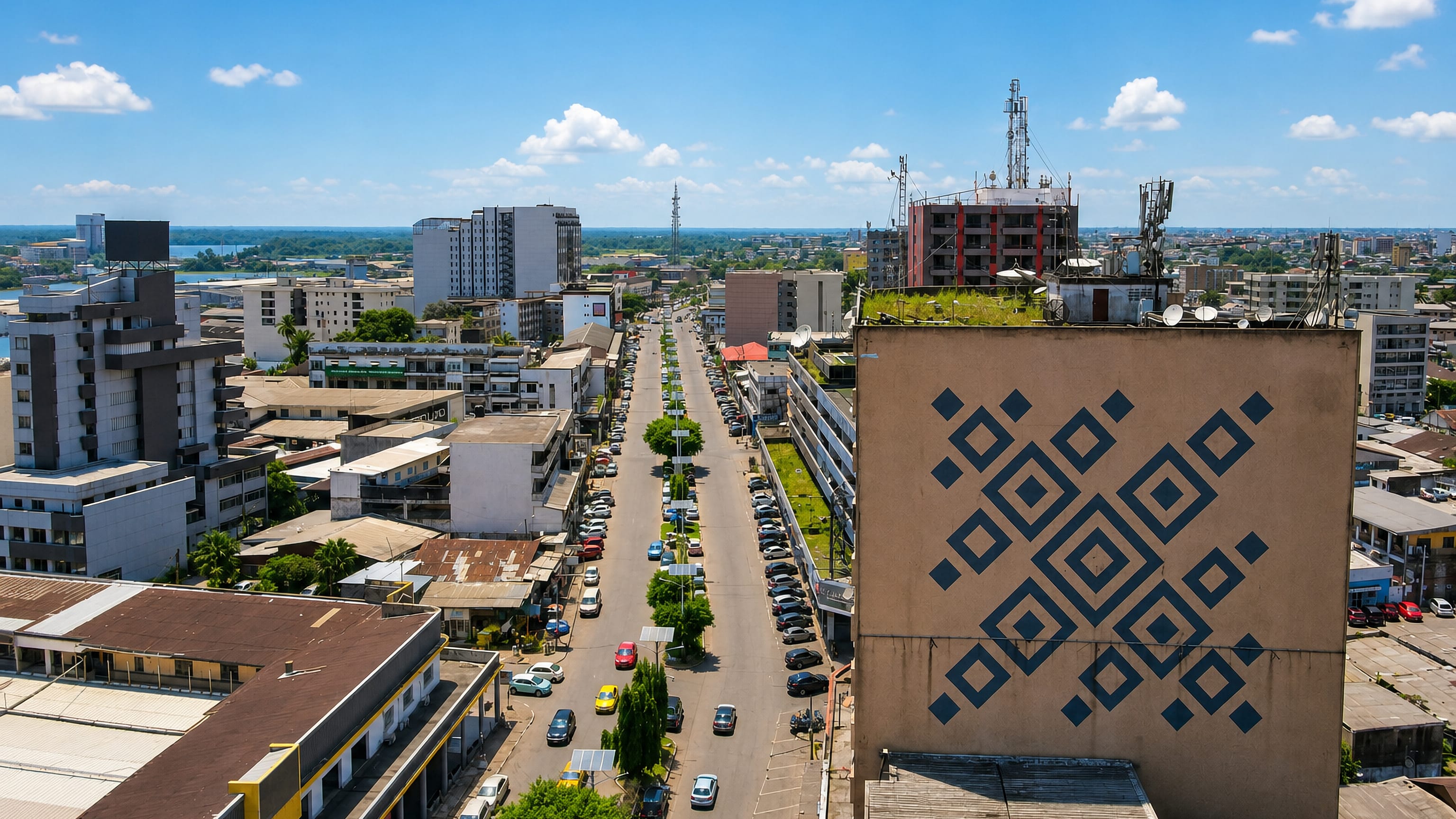 Aerial view over Akwa, Douala, along a tree-lined boulevard toward the Wouri estuary.