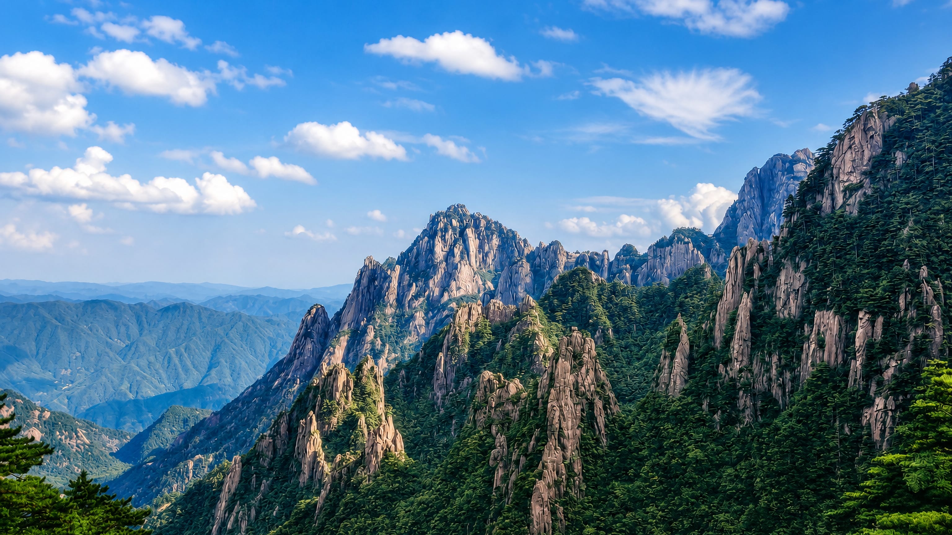 Granite peaks and pines of the Yellow Mountains rising above forested ridges at Huangshan, Anhui, China
