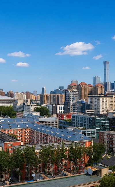 Beijing skyline with the CBD towers rising beyond red-roofed residential blocks, seen from Dongcheng District.