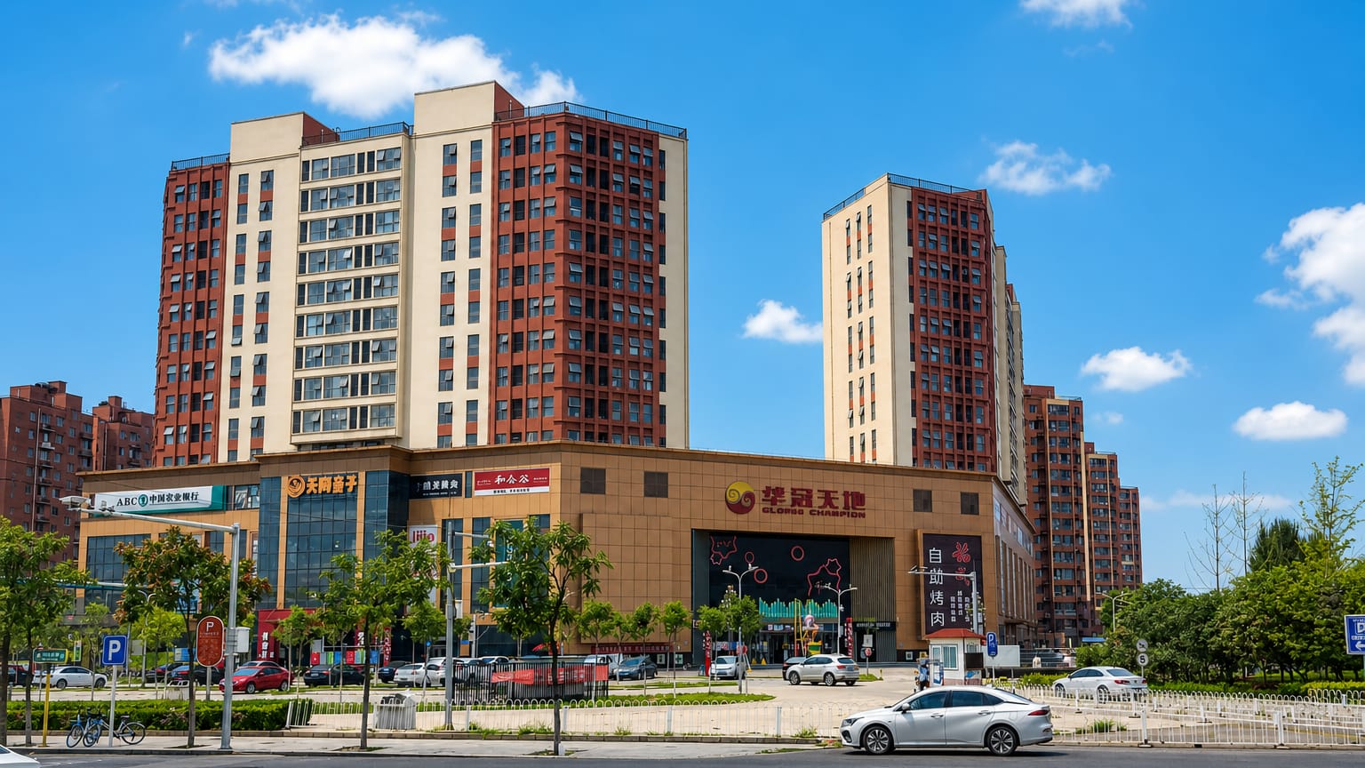 A modern shopping plaza and red-brick residential high-rises in Beijing's Fangshan District on a sunny day.