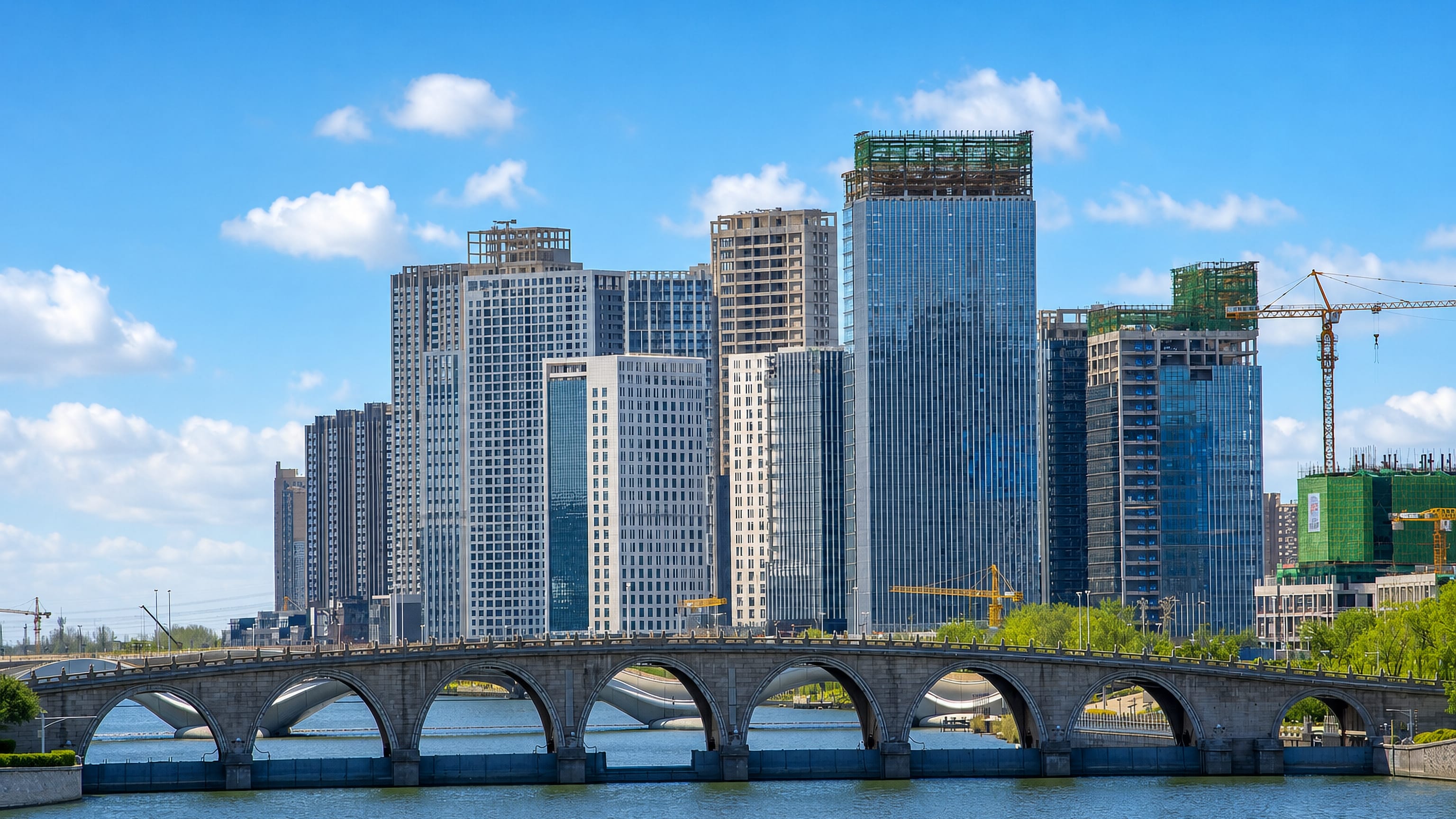 Stone arch bridge over the canal below the rising high-rise sub-centre of Tongzhou District, Beijing.