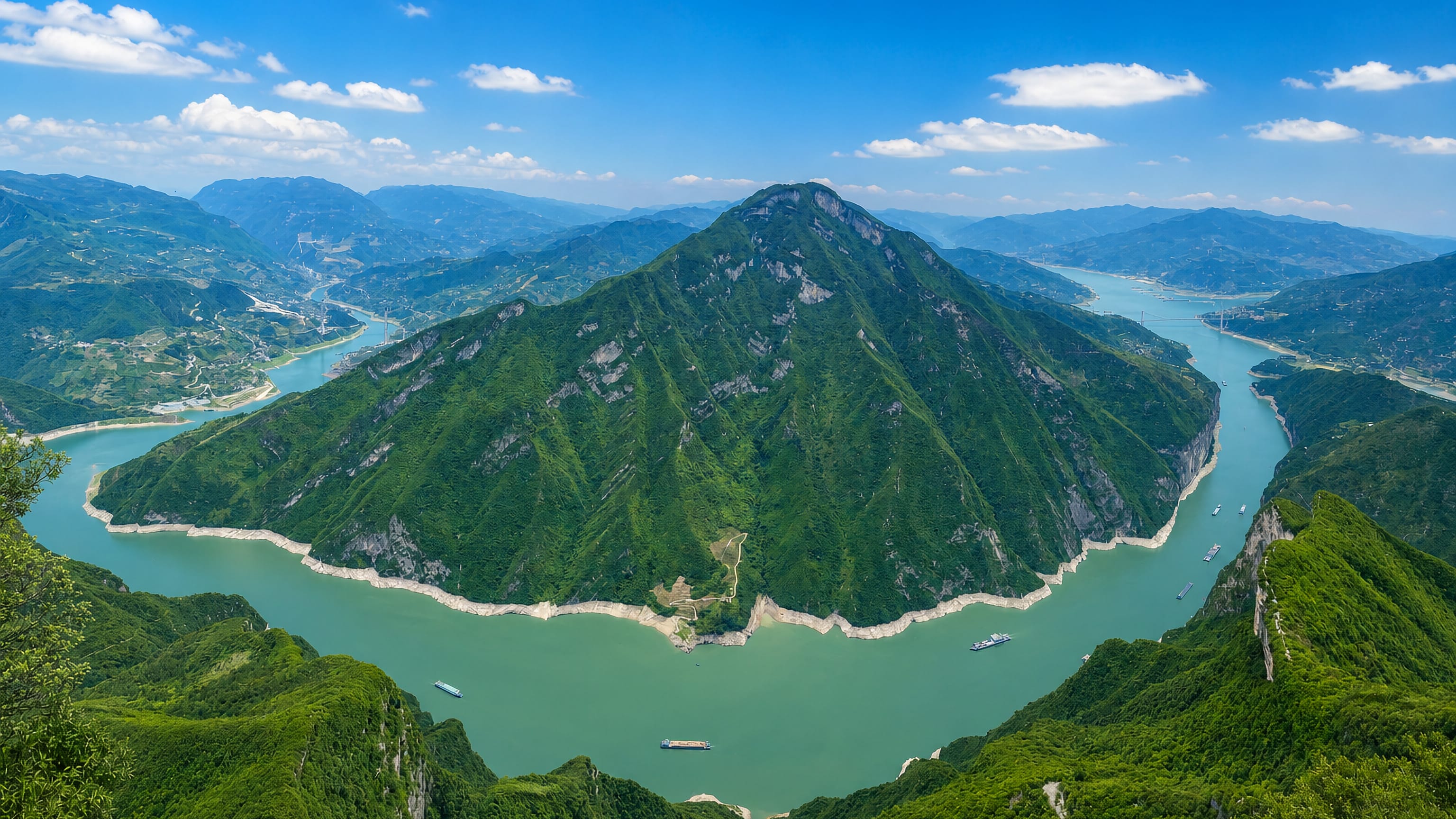 The Yangtze River curving around a forested peak in Fengjie County, Chongqing, with cargo boats below