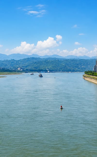 High-rise apartments lining the Yangtze River with mountains behind in Jiangjin District, Chongqing