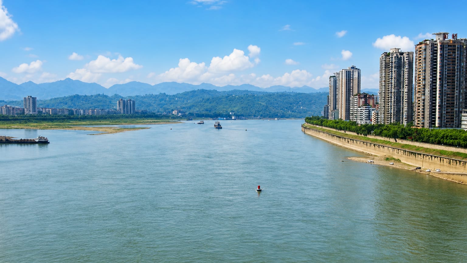 High-rise apartments lining the Yangtze River with mountains behind in Jiangjin District, Chongqing