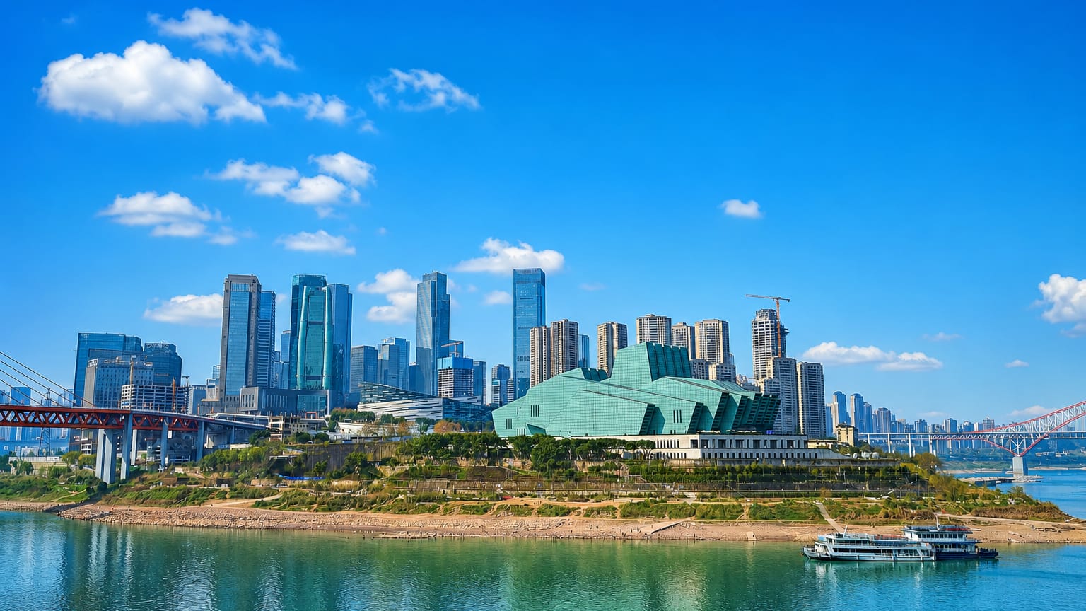 Liangjiang New Area skyline across the Yangtze in Chongqing, with the green-glass Grand Theatre and high-rise towers under a clear sky