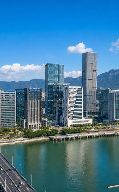 Fuzhou's riverside business district with a bridge over the Min River and mountains behind.