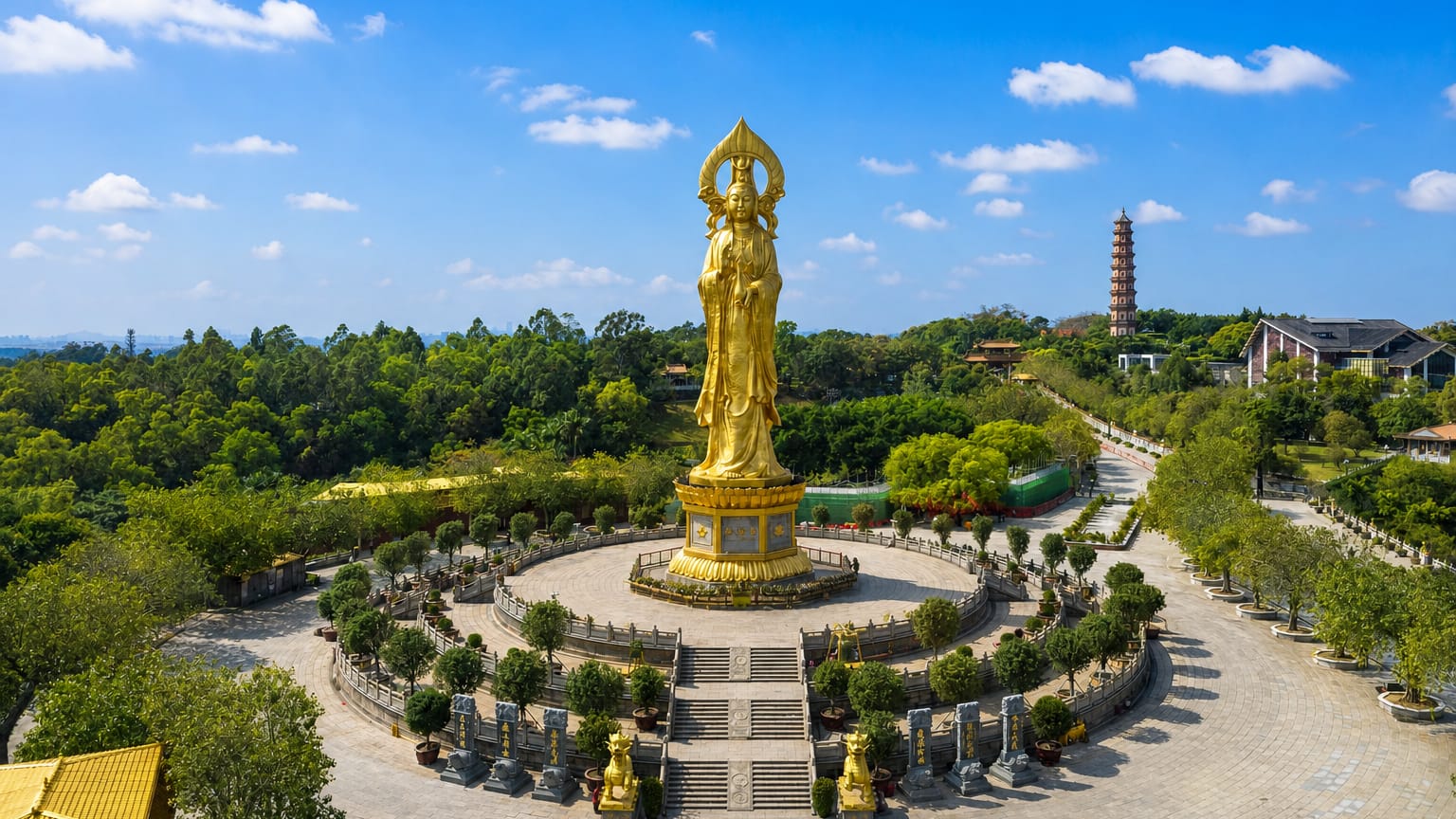 The giant golden Guanyin statue and pagoda at Lotus Hill in Guangzhou's Panyu District under a blue sky.