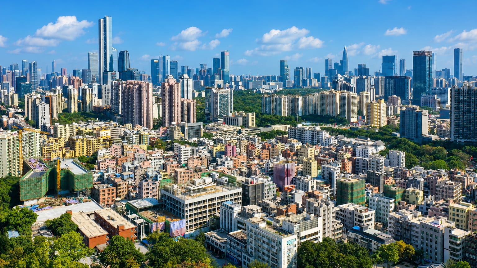 Dense high-rise cityscape with a supertall tower and green parkland in Shenzhen, China.