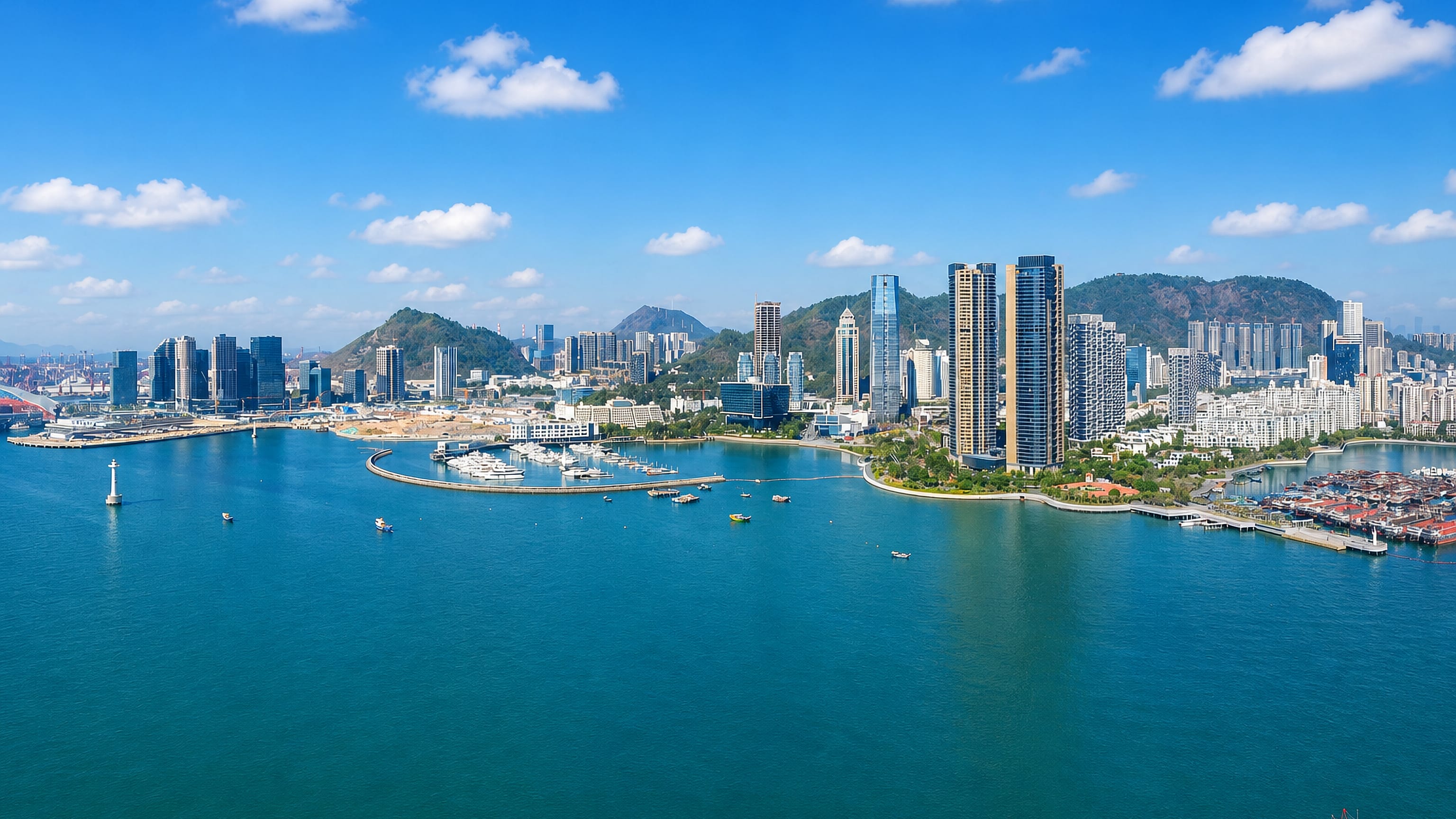 Waterfront high-rises and a marina on the bay at Nanshan District, Shenzhen, with green hills behind