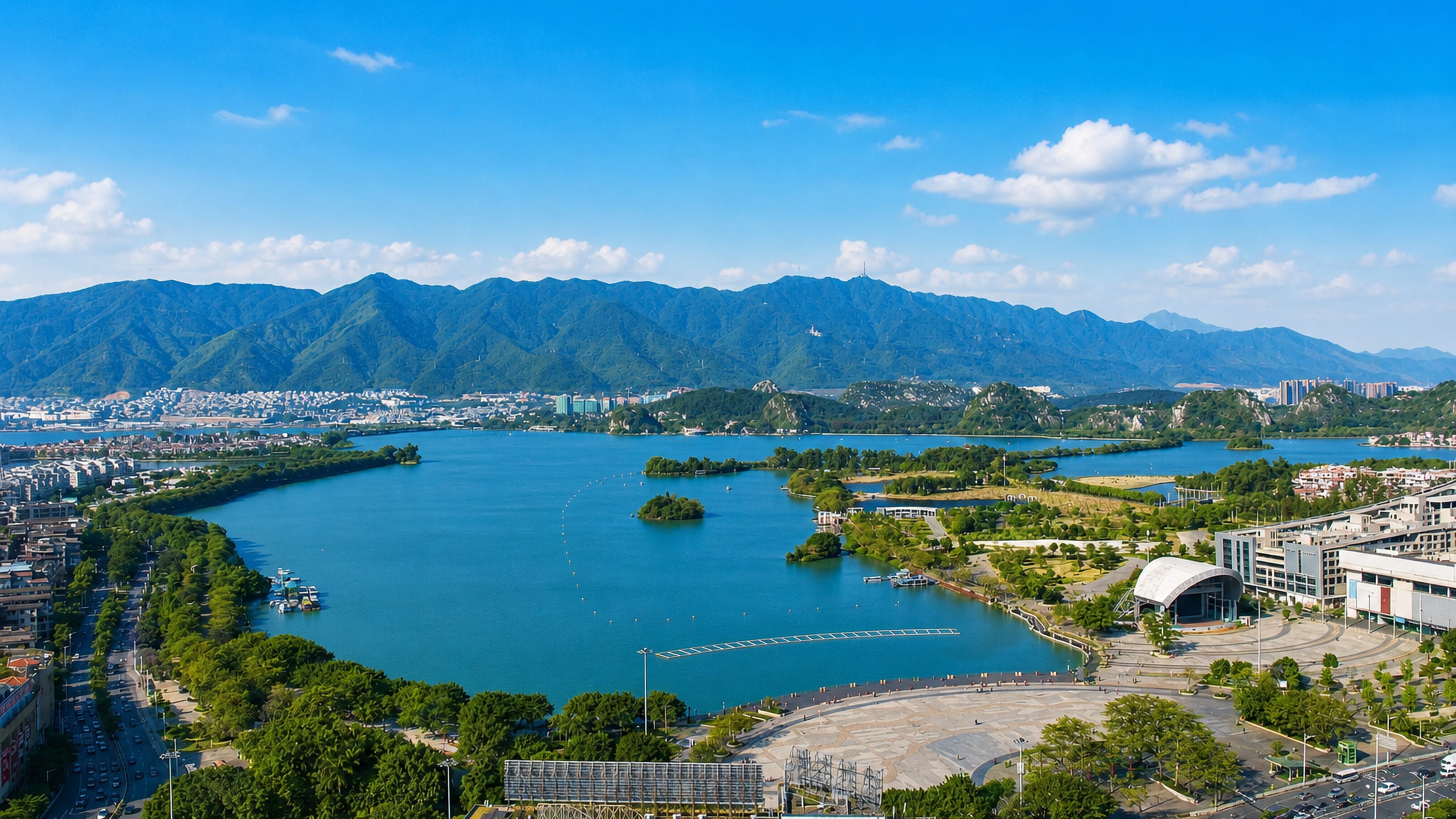 Zhaoqing's Star Lake ringed by limestone karst crags, waterfront plaza and forested mountains beyond