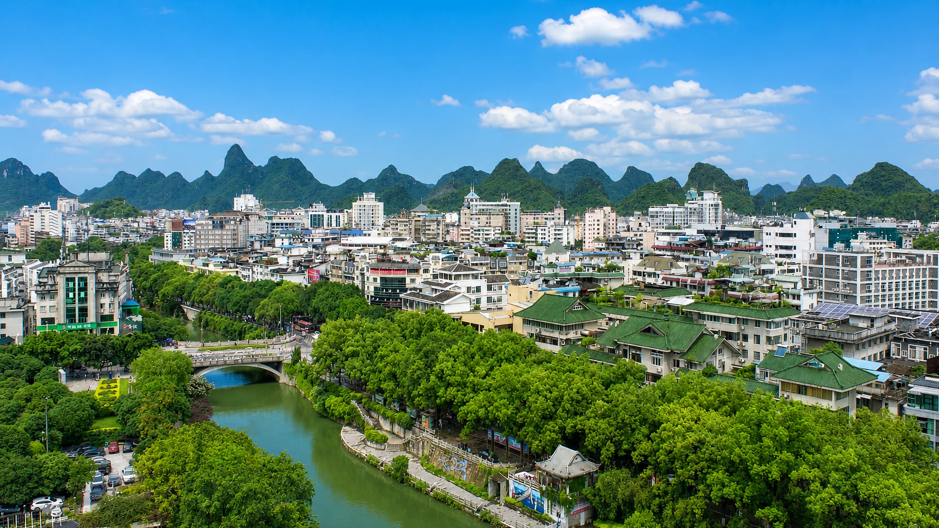 Guilin's riverside rooftops and stone bridge below the karst peaks that ring the city in Guangxi, China