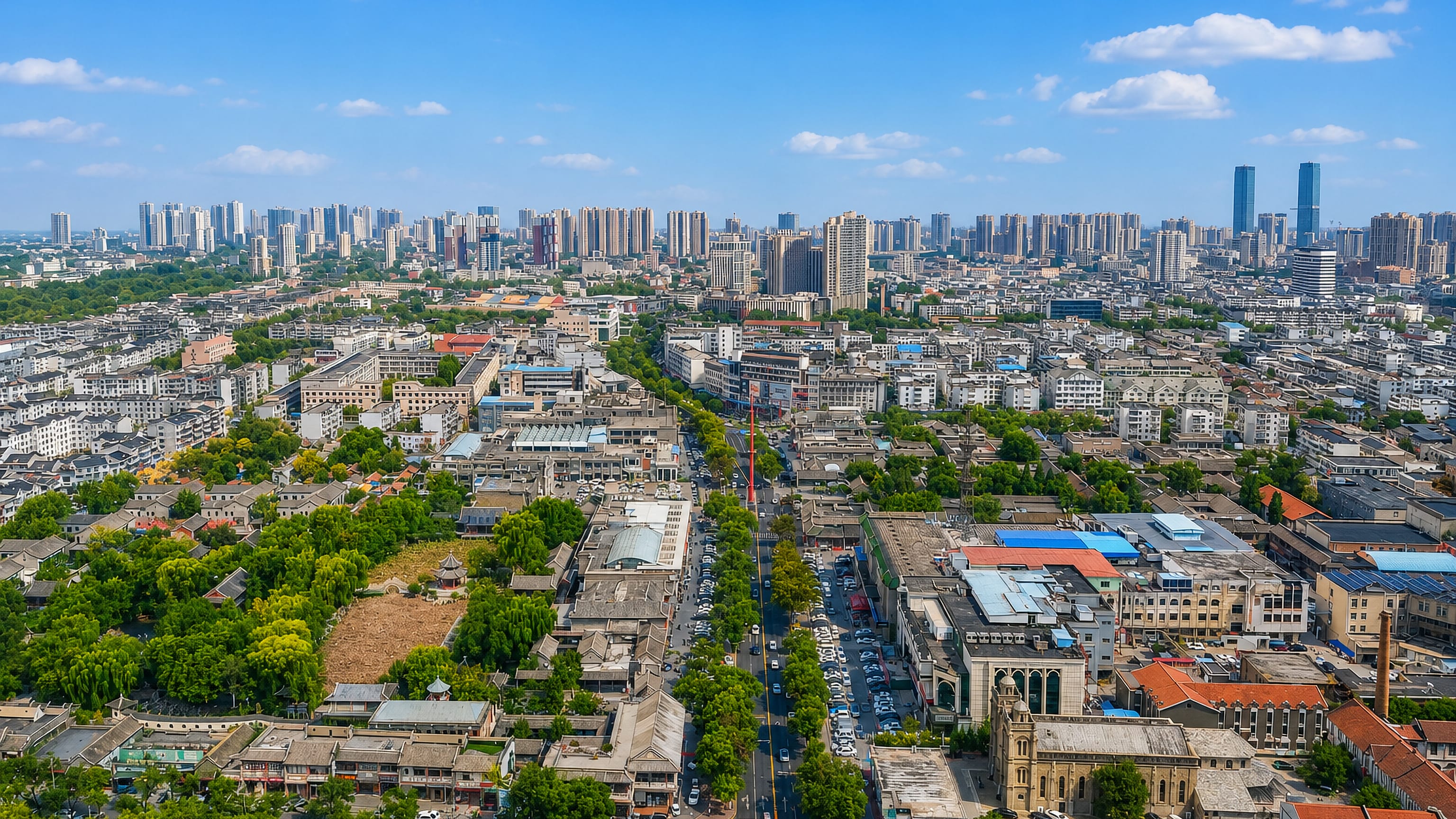 Aerial view of Baoding with grey-tiled courtyard streets in the foreground and high-rise towers behind.