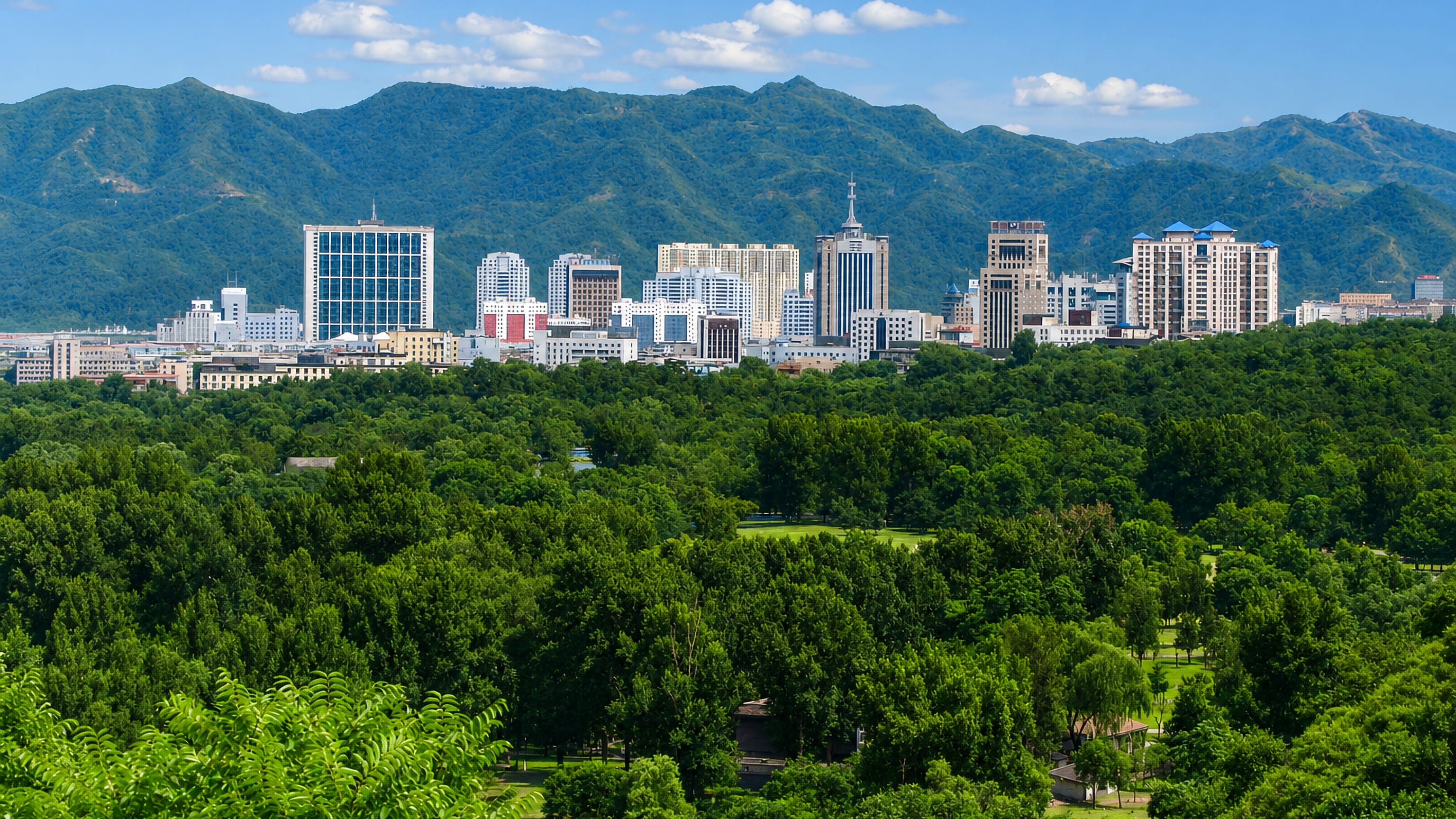 Chengde's modern skyline rising beyond the wooded parkland of the Mountain Resort, ringed by mountains.