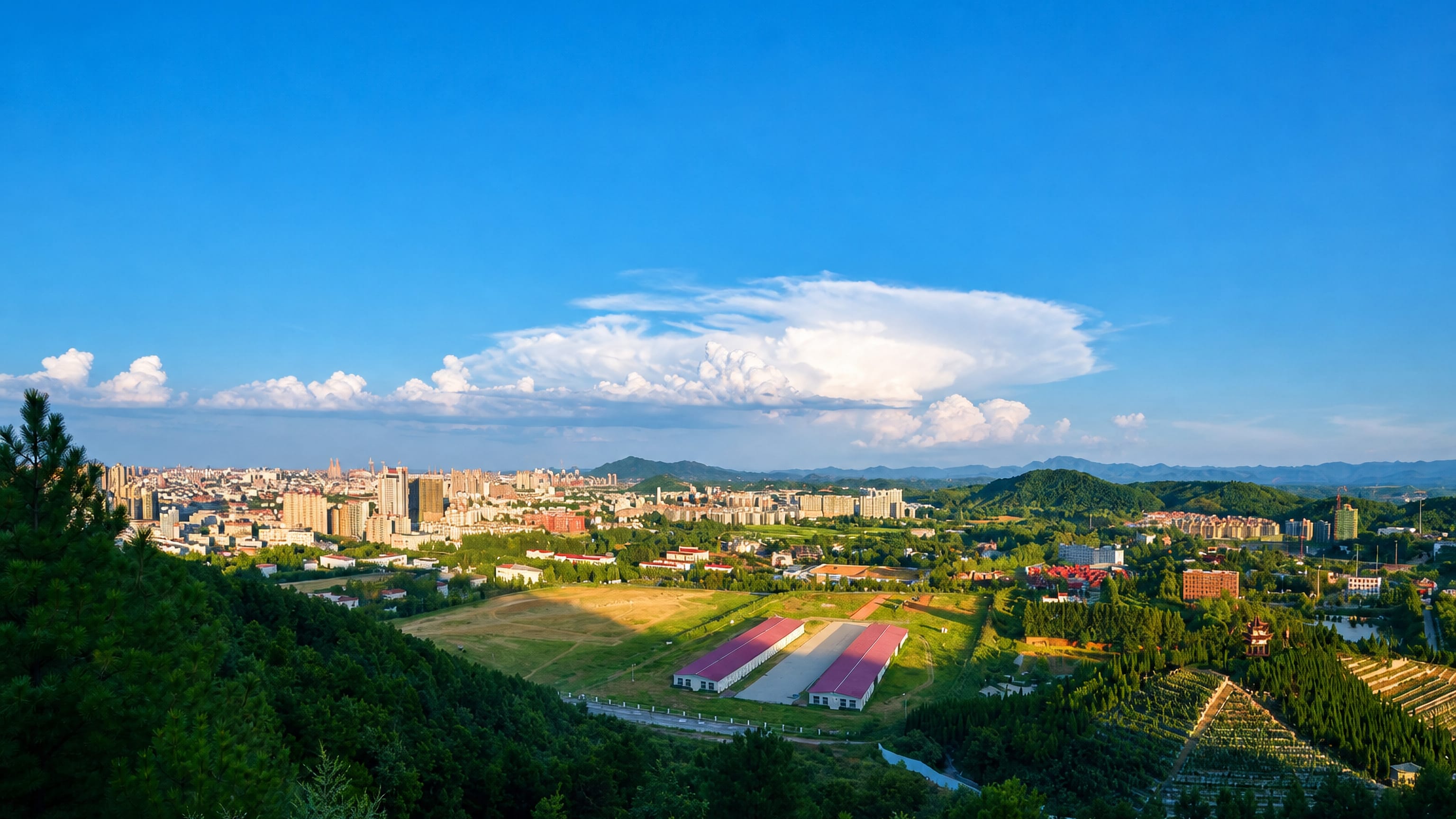 Xinyang, Henan, seen from wooded hills with tea terraces and farmland in the foreground