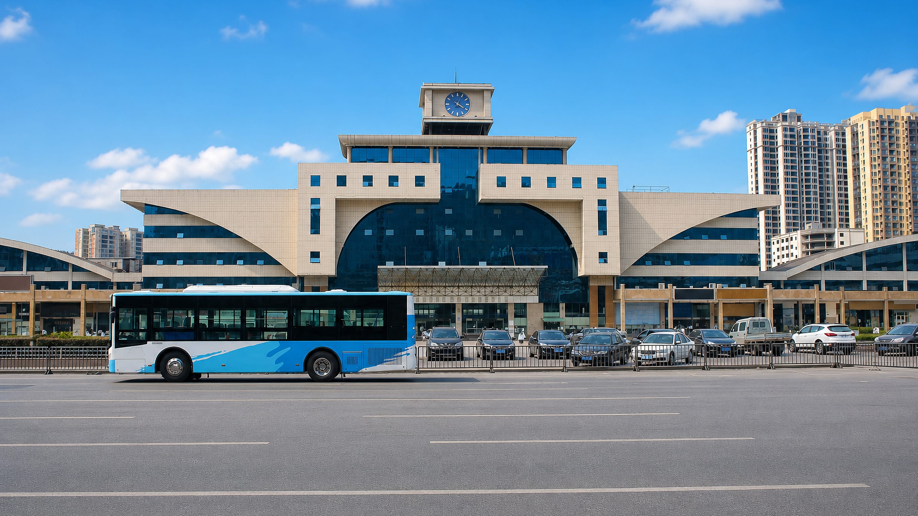Clock-towered civic station building in Shiyan, China, with a city bus on the broad avenue in front.