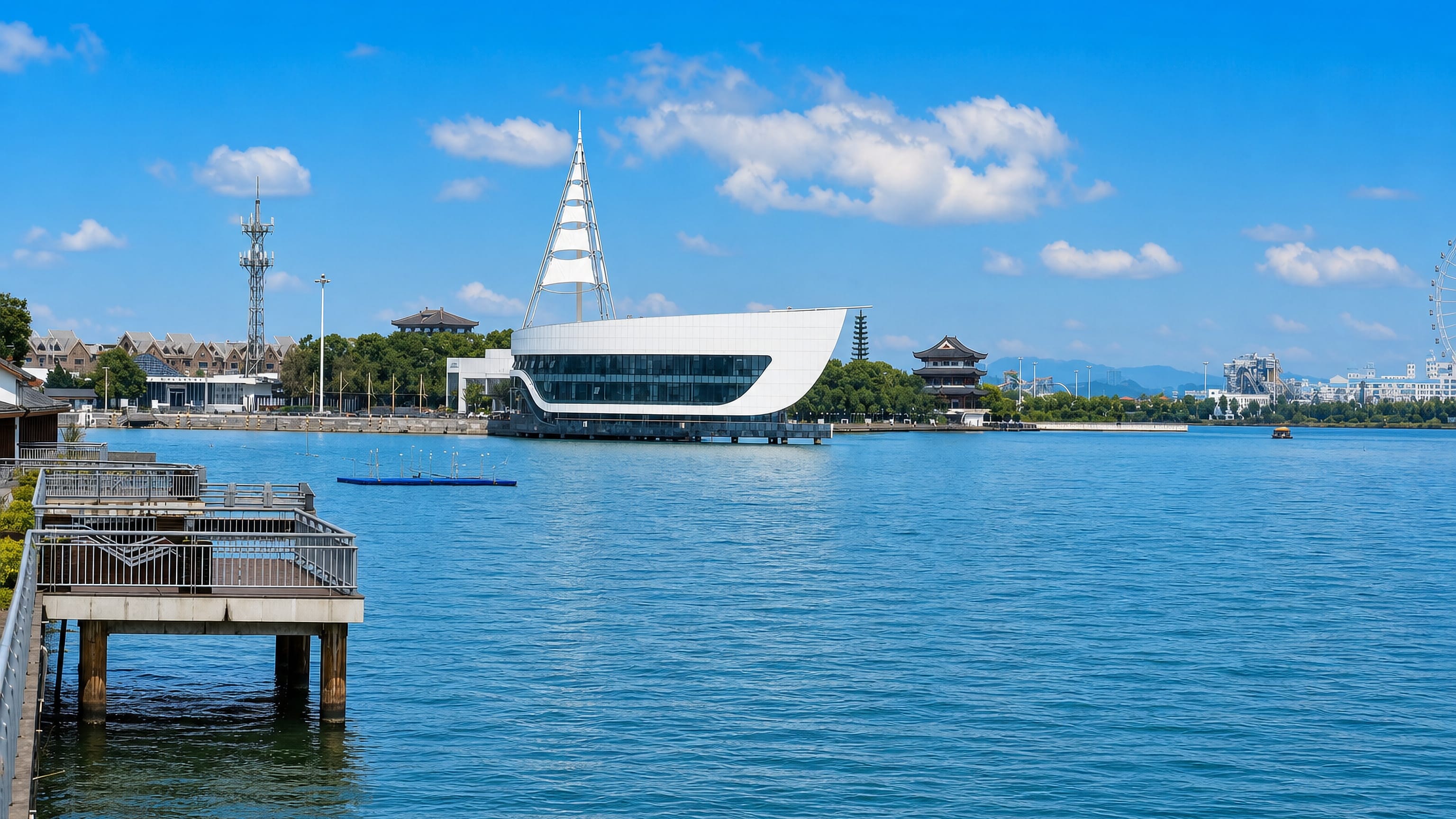 Sail-shaped lakeside building and Chinese pavilions on the waterfront at Changde, Hunan.