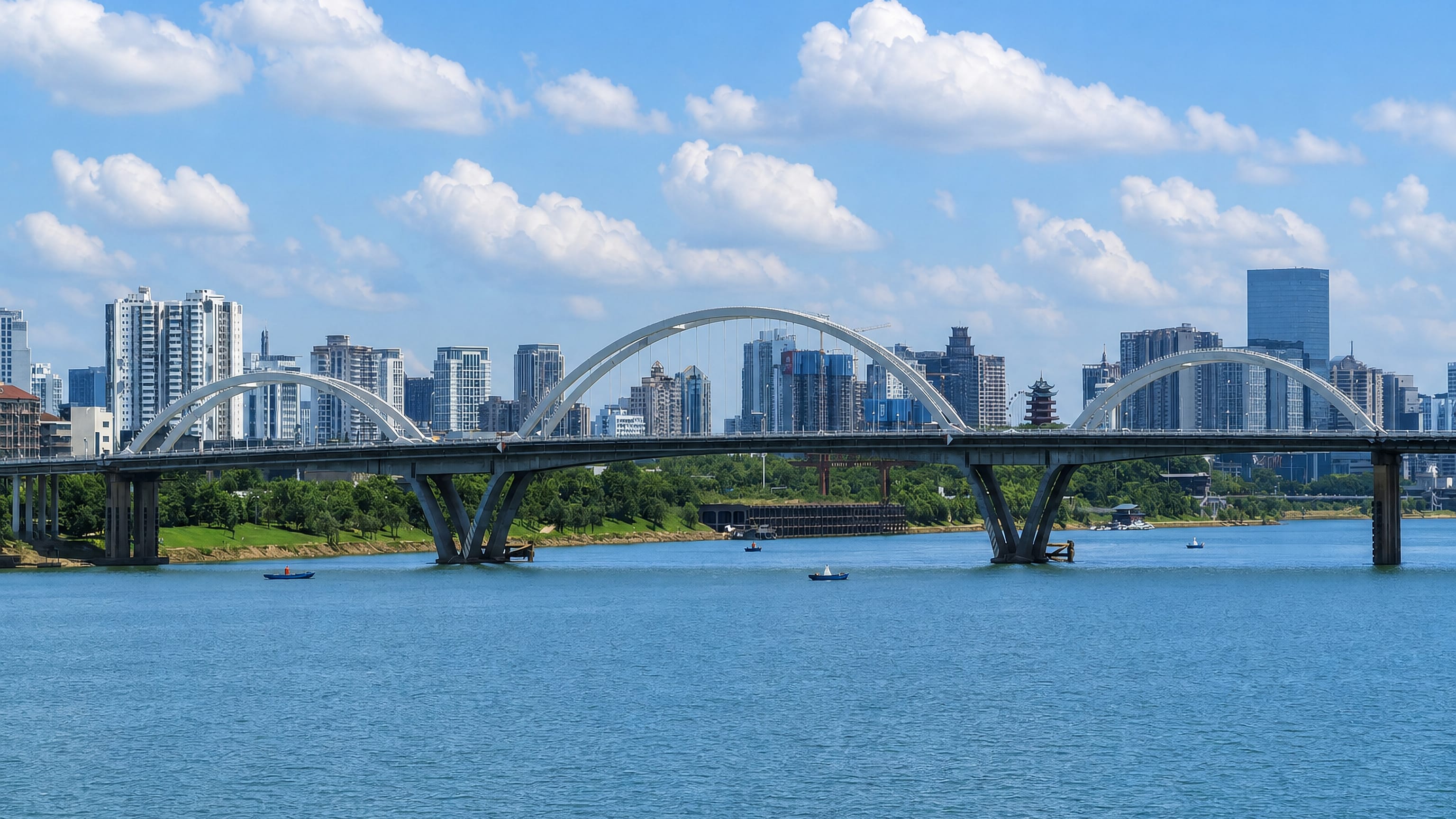 Arched road bridge over the Xiang River with Zhuzhou's high-rise skyline rising behind it.