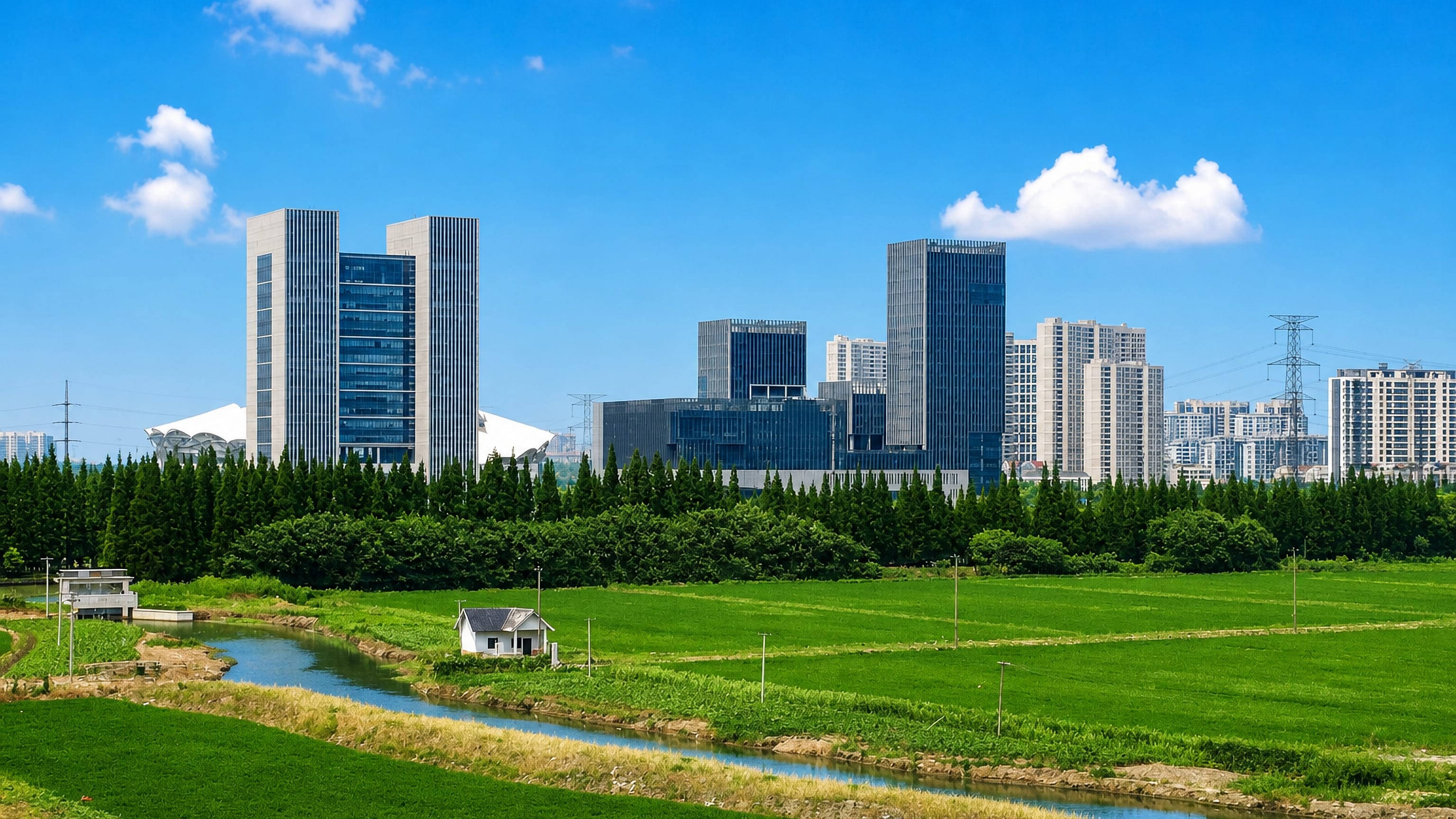 High-rise towers of Kunshan, Jiangsu rising beyond a conifer belt, rice paddies and an irrigation canal.