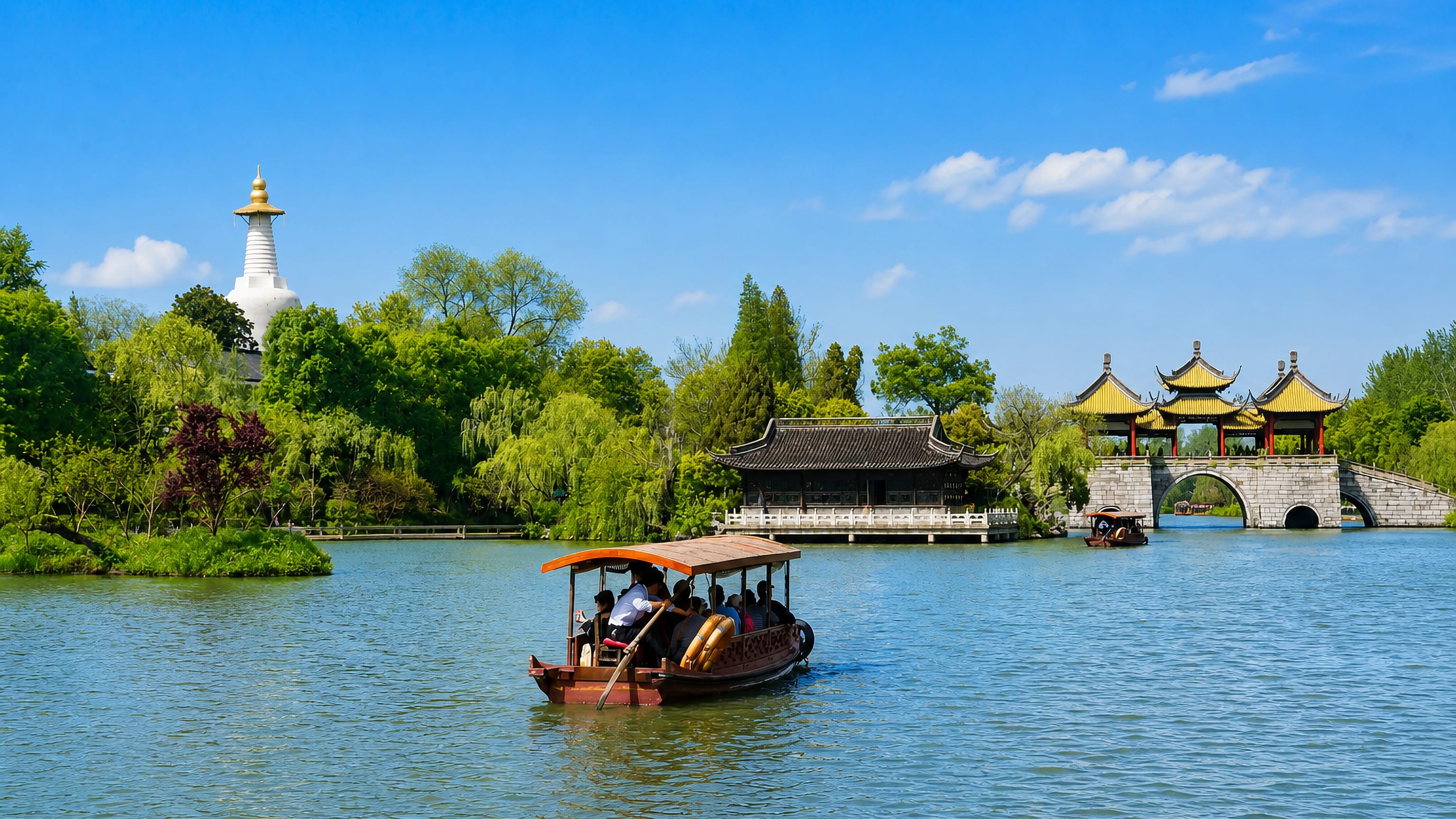 A tour boat crosses Slender West Lake past the White Pagoda and Five Pavilion Bridge in Yangzhou.