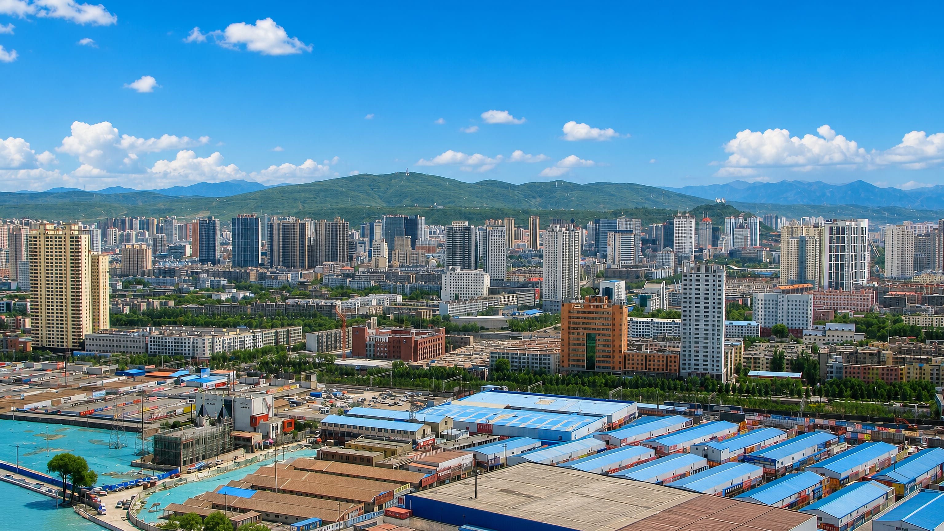 Xining spread across its Qinghai valley, high-rise blocks backed by green mountains above riverside depots.