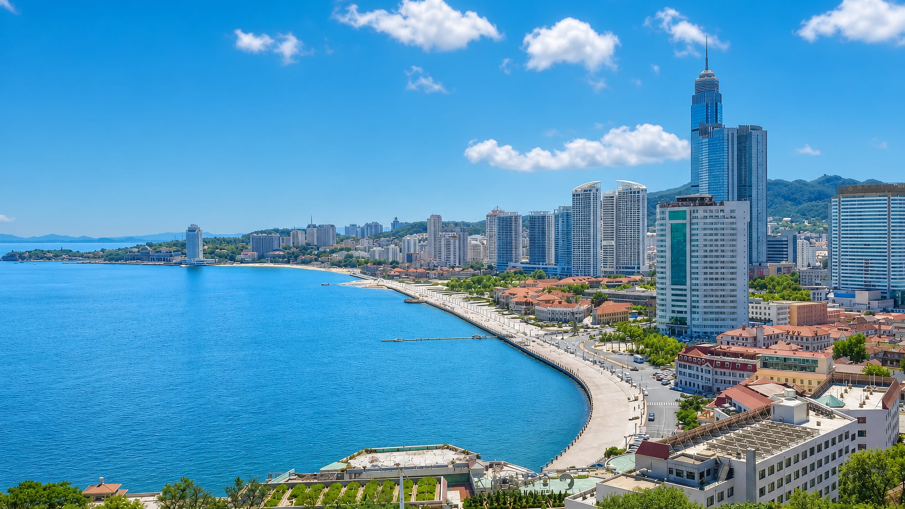 Yantai's curving bayfront promenade and seaside towers along the Bohai coast in Shandong, China.