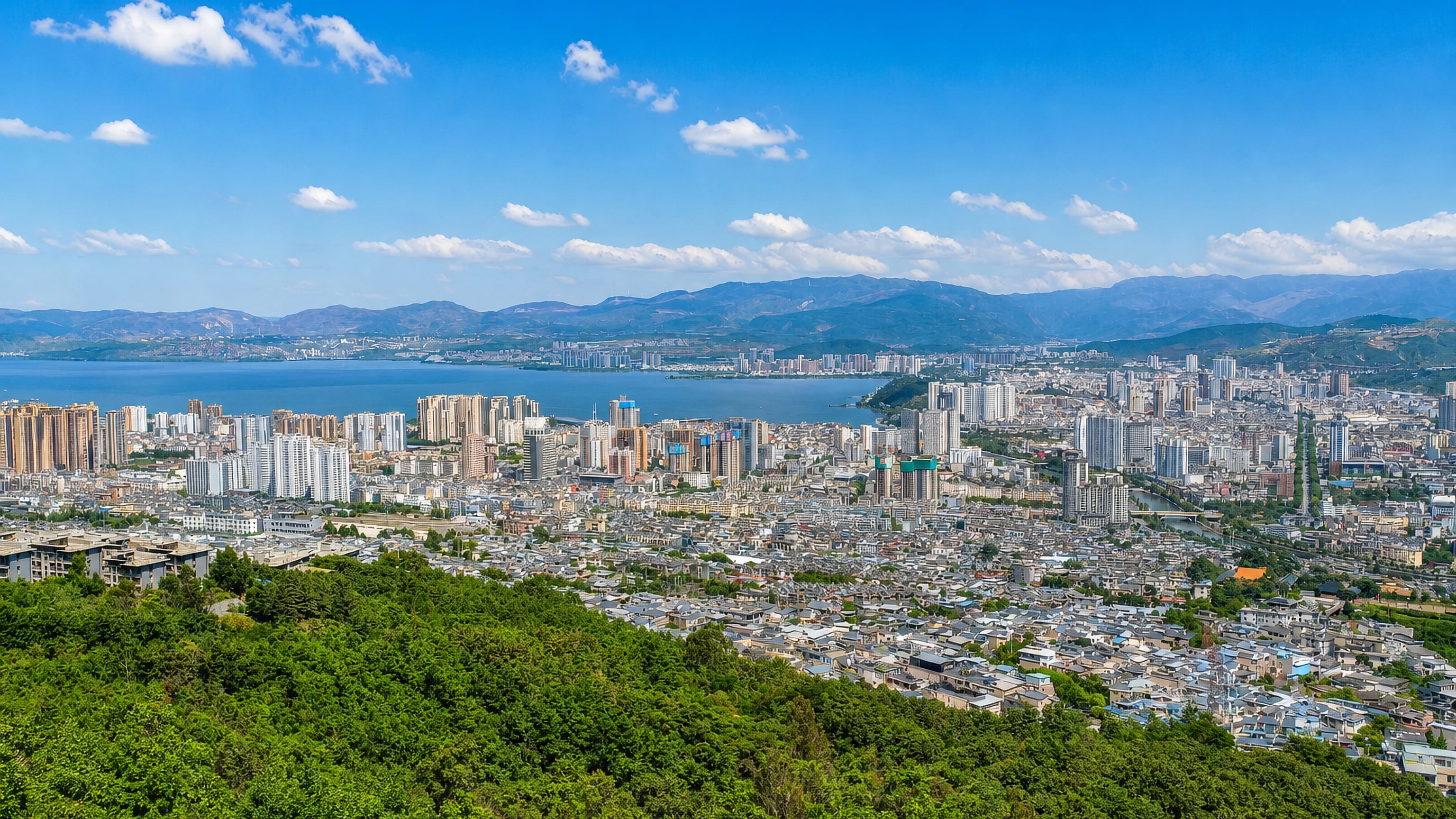 Dali, Yunnan, its high-rise waterfront along Erhai Lake ringed by mountains and green wooded slopes.