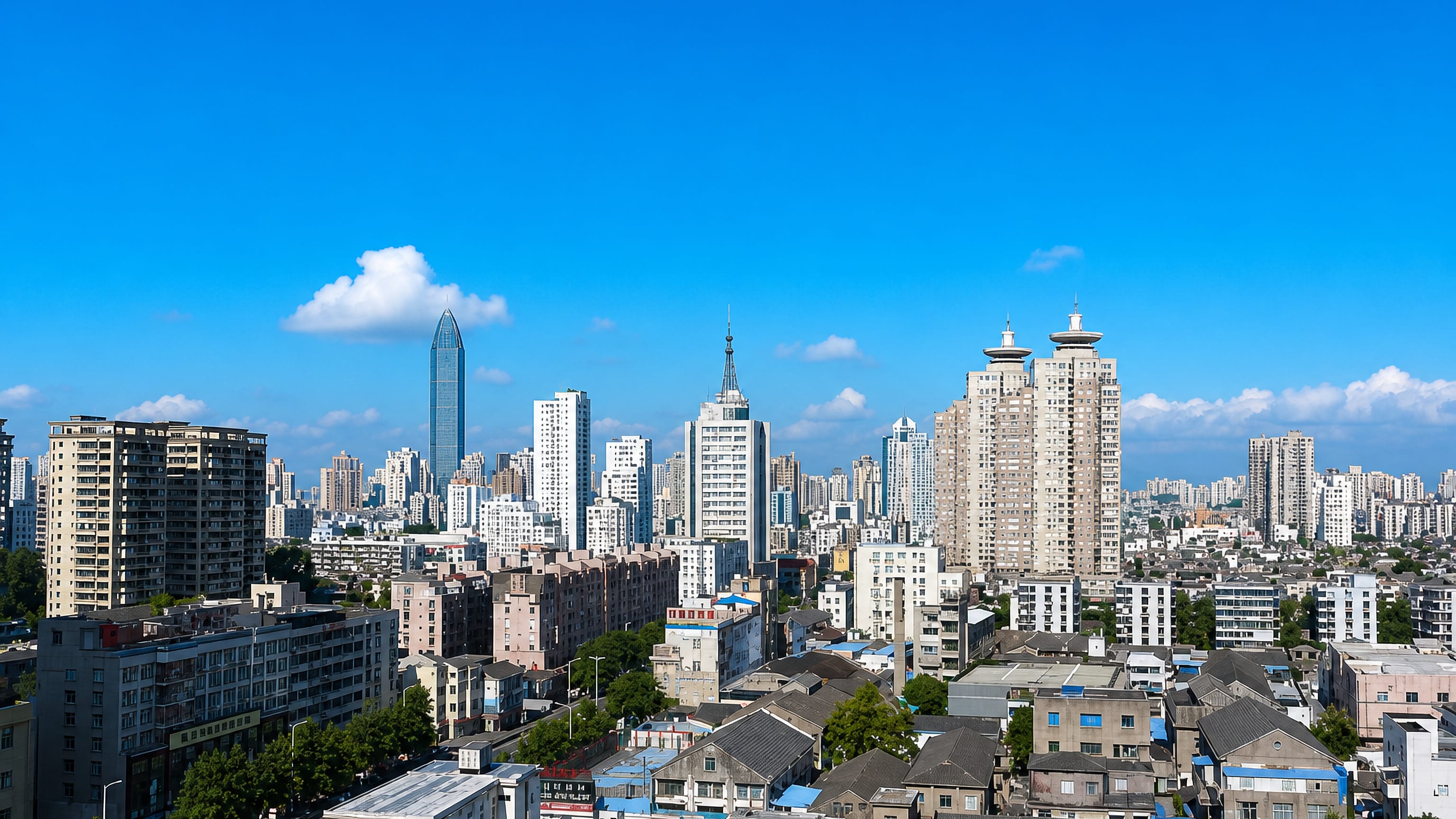 Wenzhou skyline of dense low-rise rooftops with a tapered glass tower rising above Zhejiang apartment blocks.