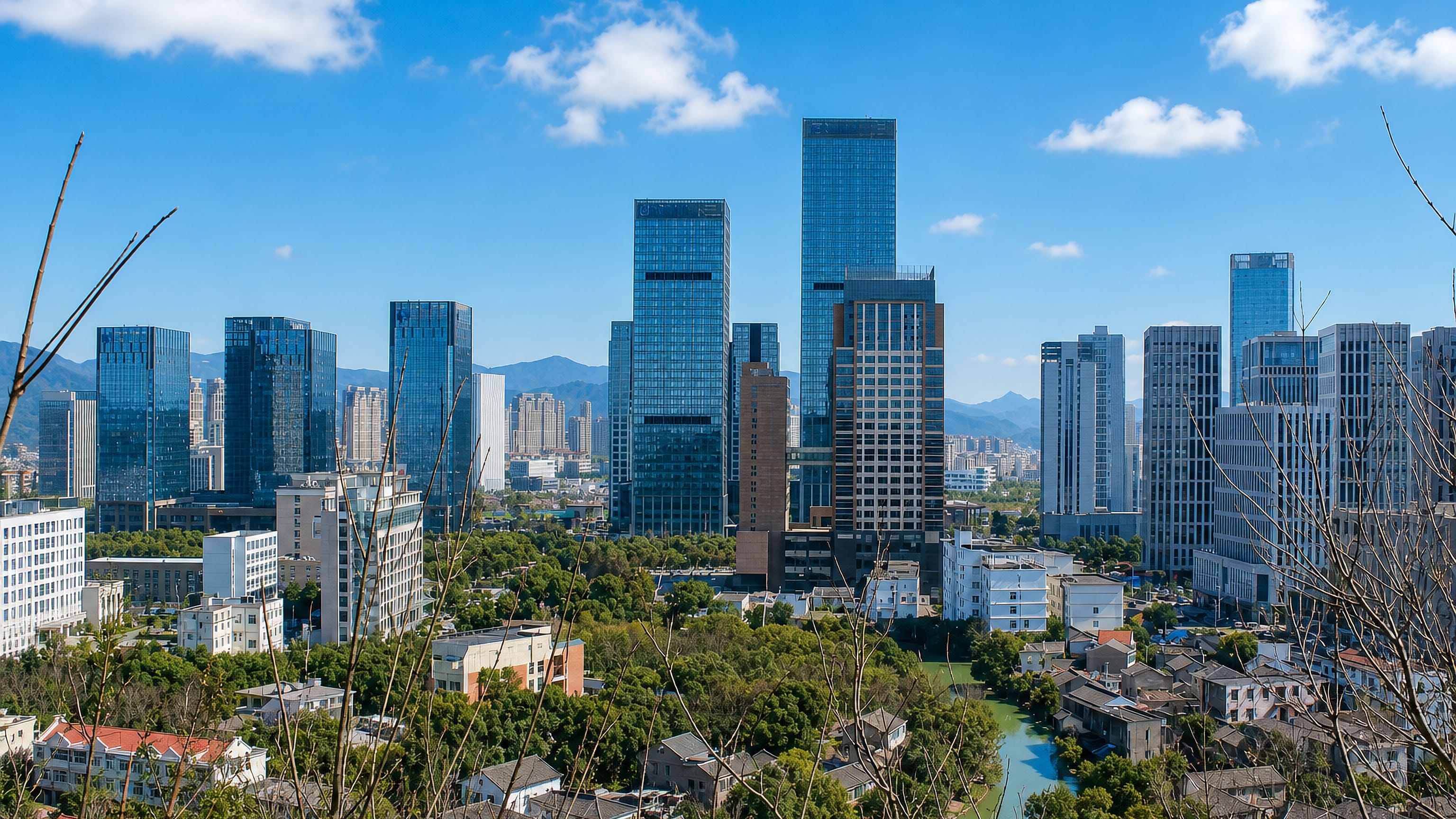 Zhoushan's Lincheng district skyline, glass office towers above low-rise streets with coastal hills beyond.