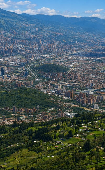 Panoramic aerial of the Aburra Valley with Medellin's cityscape climbing the slopes above the El Poblado district