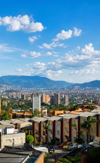 Red-brick apartment blocks on a Medellin hillside overlooking the Aburra Valley and surrounding Andean mountains in Robledo.