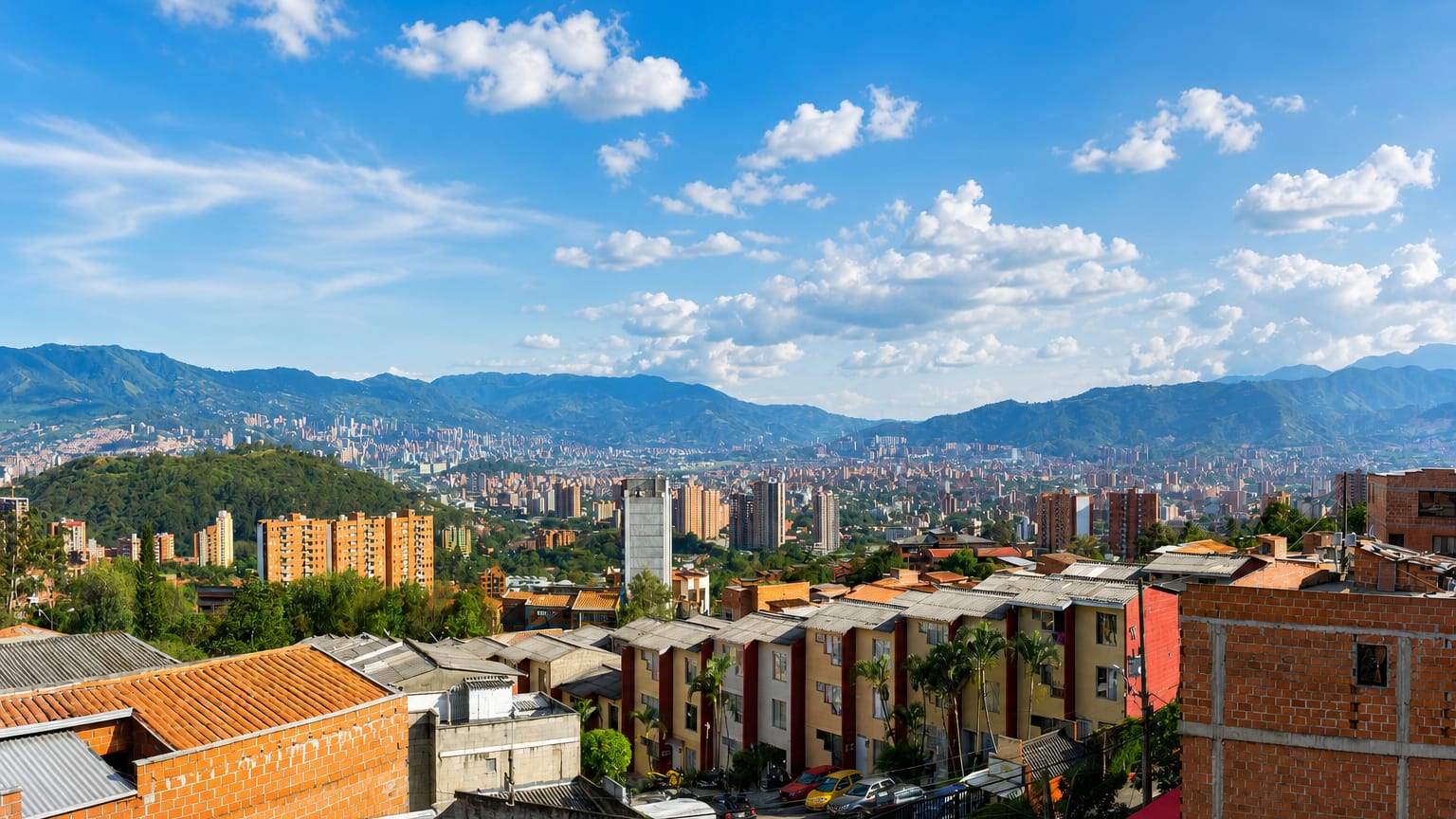 Red-brick apartment blocks on a Medellin hillside overlooking the Aburra Valley and surrounding Andean mountains in Robledo.
