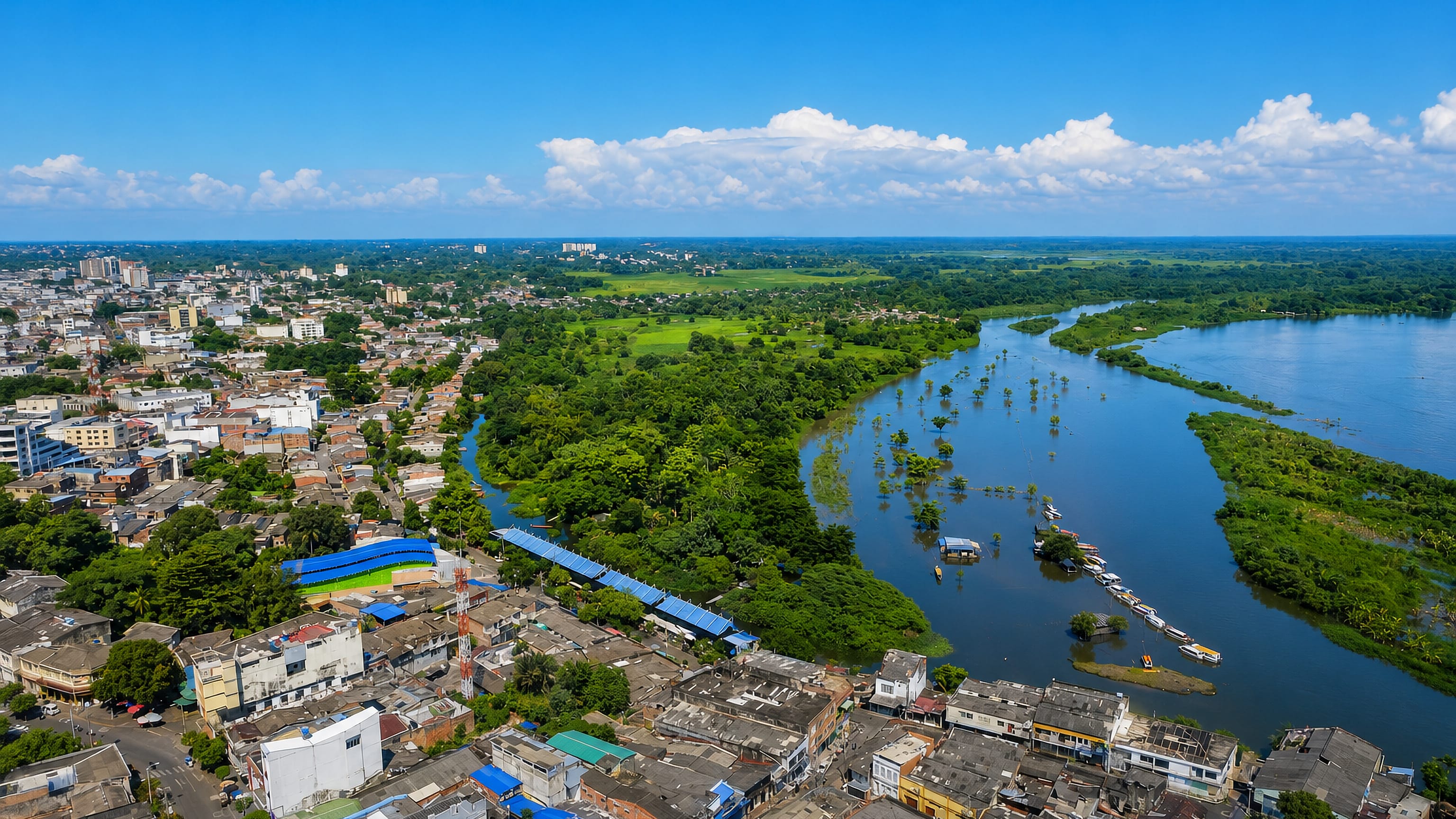 Barrancabermeja, Colombia, low-rise riverside streets meeting the wide Magdalena River and its wetlands.