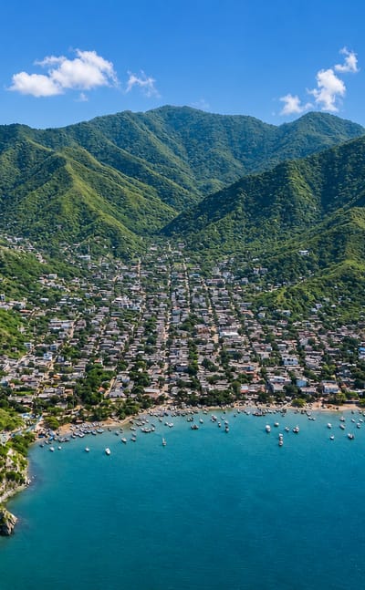 Fishing boats dot a sheltered bay below green coastal mountains near Santa Marta.