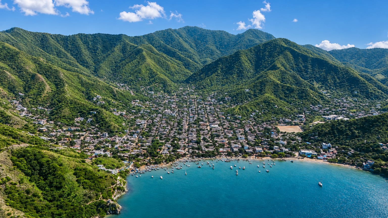 Fishing boats dot a sheltered bay below green coastal mountains near Santa Marta.