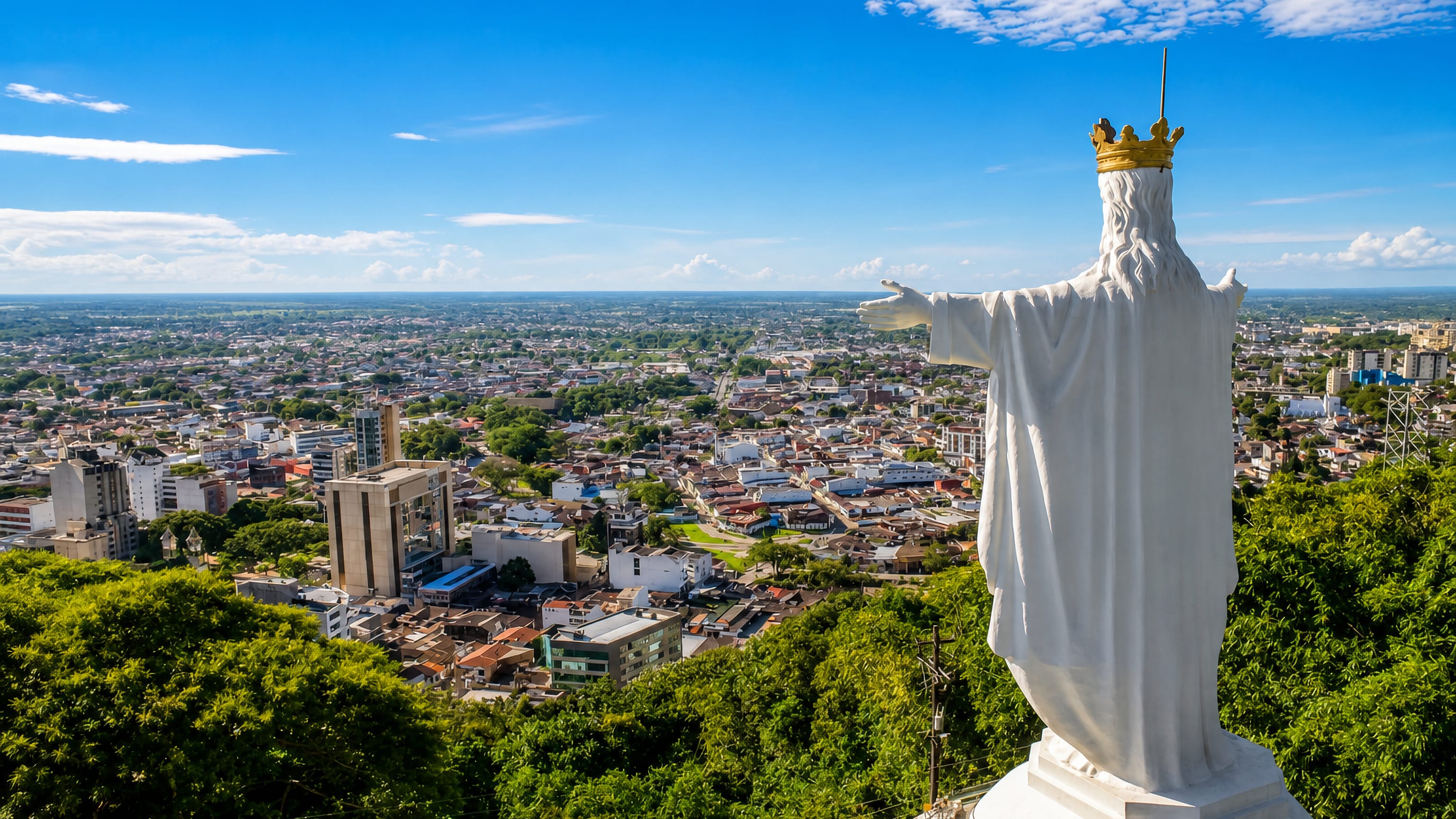 A white Christ the King statue on a wooded hilltop overlooking Villavicencio and Colombia's flat Llanos plains.