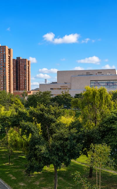 A green park with a bike path, brick apartment towers and a domed convention hall in the Engativa locality of Bogota