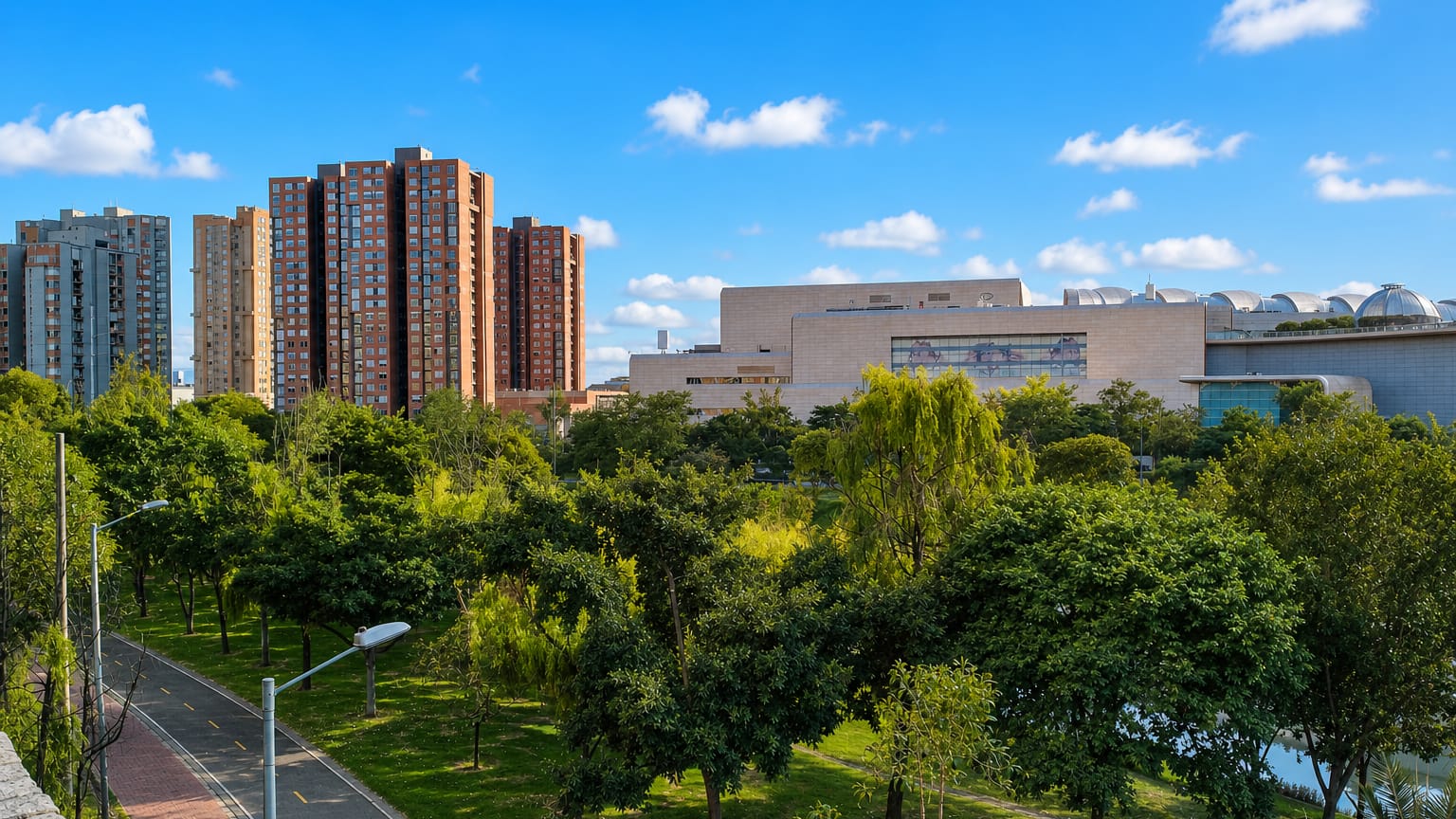 A green park with a bike path, brick apartment towers and a domed convention hall in the Engativa locality of Bogota