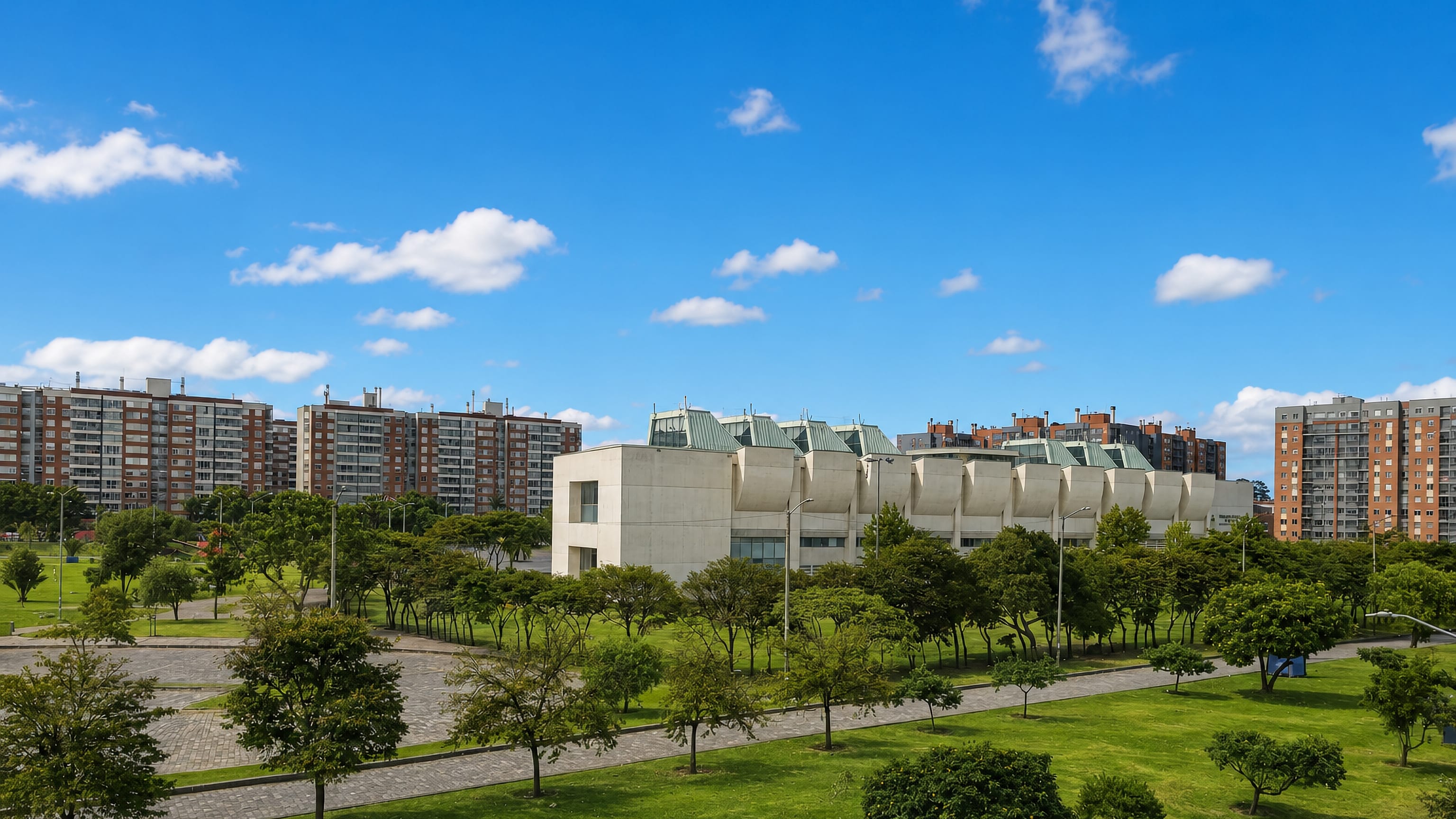 Brick apartment blocks and a concrete civic building above a green park in Kennedy, Bogotá.