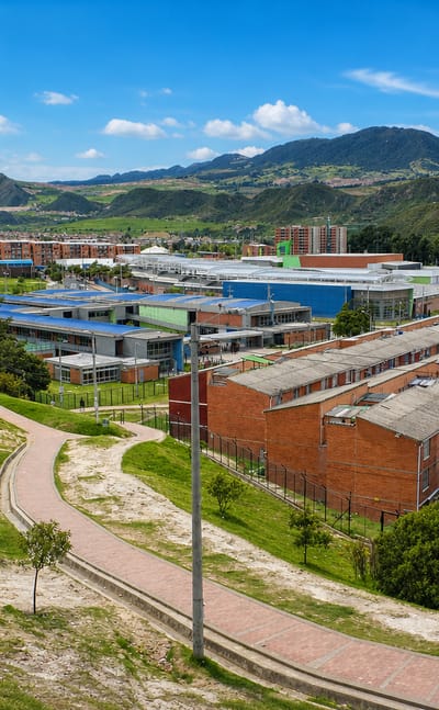 Brick row-houses and apartment blocks of the Usme locality against the green Andean hills of southern Bogota