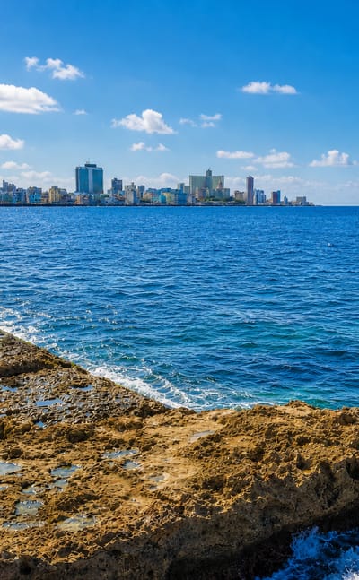 Havana's Vedado skyline across the sea from the rocky Malecon shoreline.