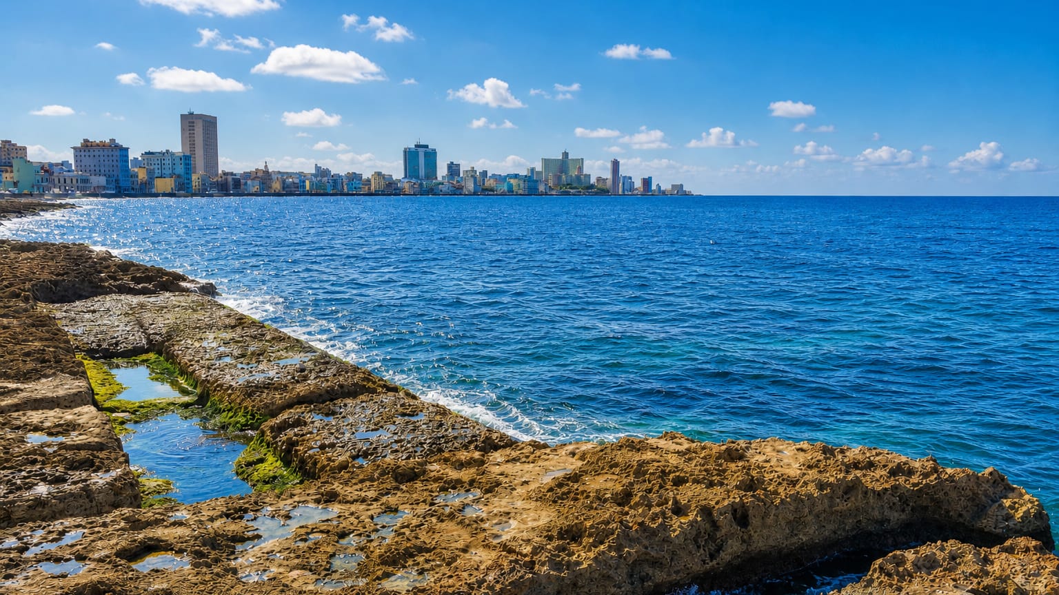 Havana's Vedado skyline across the sea from the rocky Malecon shoreline.